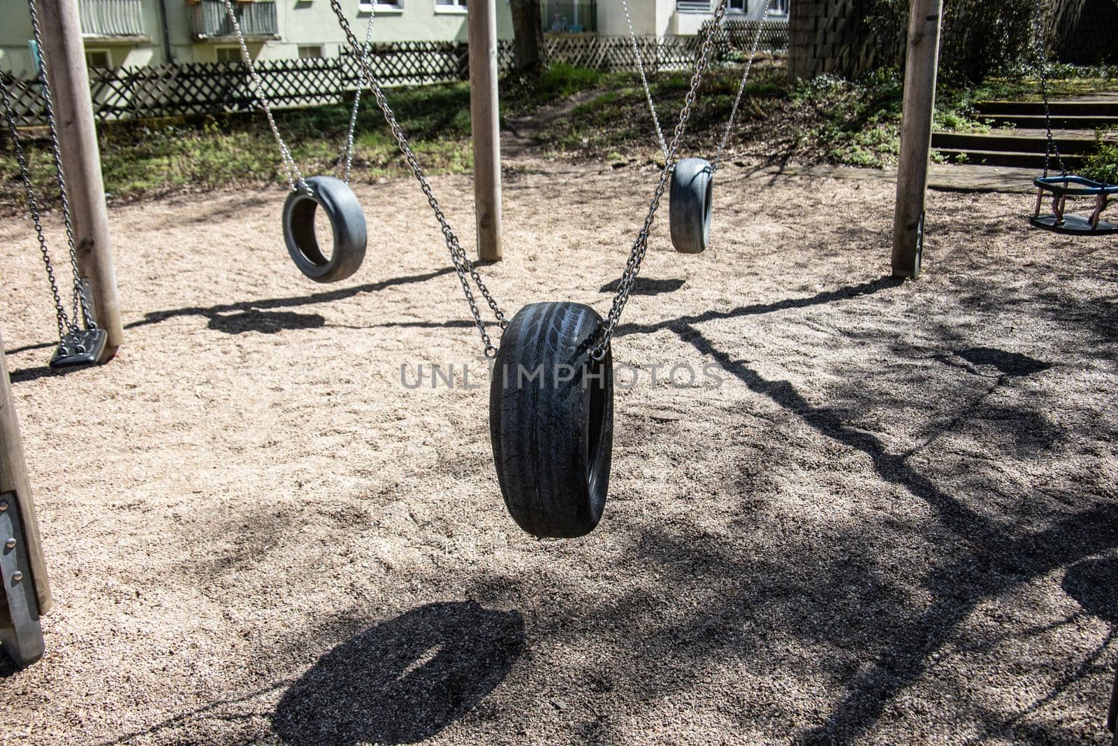 Playground in the sandpit with rubber tires as a swing