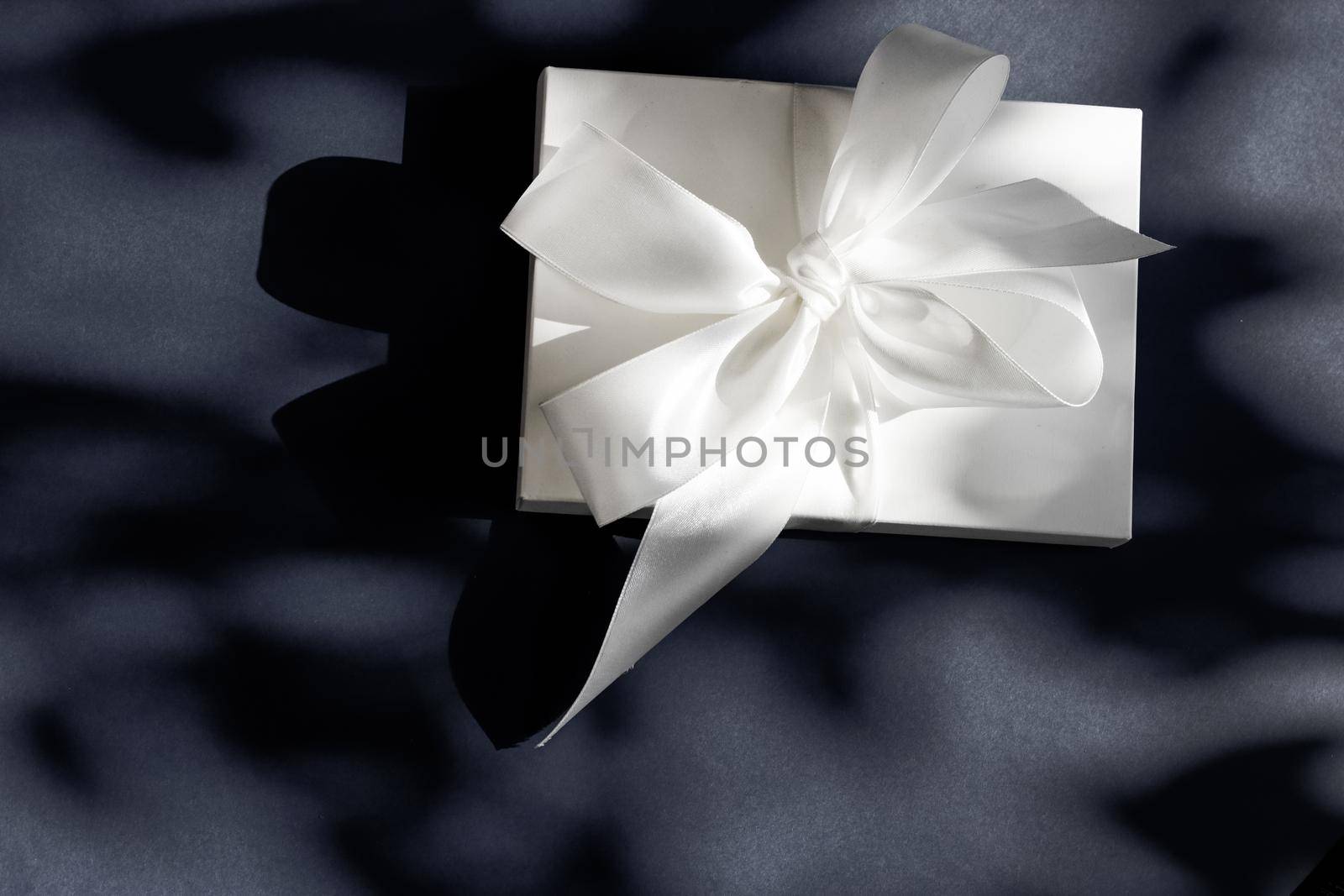 Anniversary celebration, shop sale promotion and luxe surprise concept - Luxury holiday white gift box with silk ribbon and bow on black background, luxe wedding or birthday present