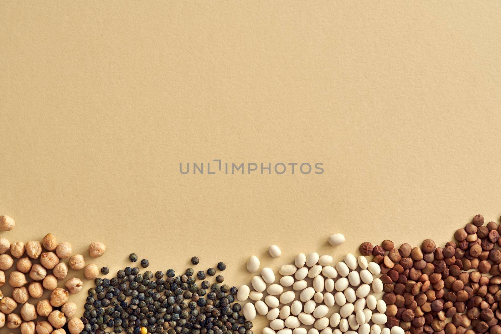Chickpeas, beans and lentils - flat lay of legumes on beige background, with copy space by madeleine_steinbach