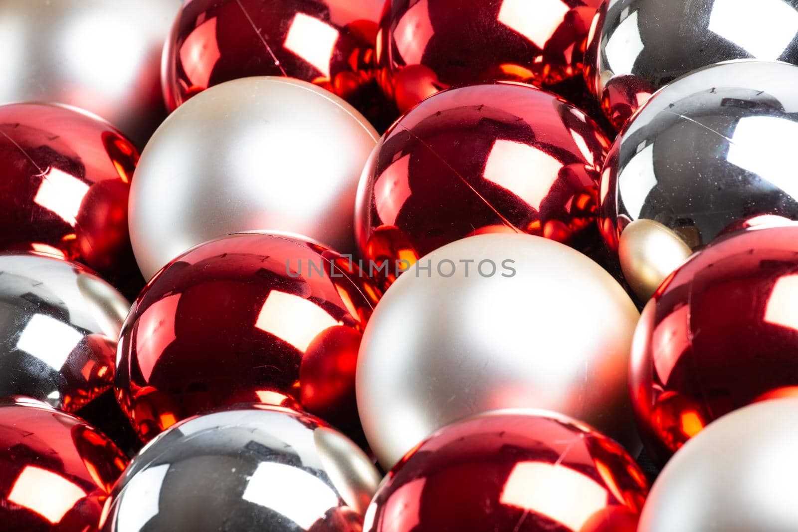 full frame background of red, silver and white mirror balls close-up with selective focus and blur