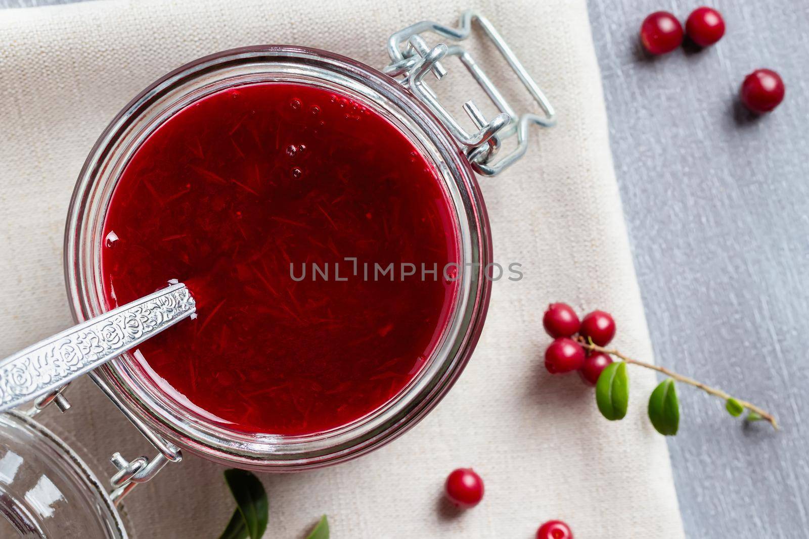 Glass jar with homemade lingonberry sauce. Canning lingonberry sauce, top view, flat lay by galsand