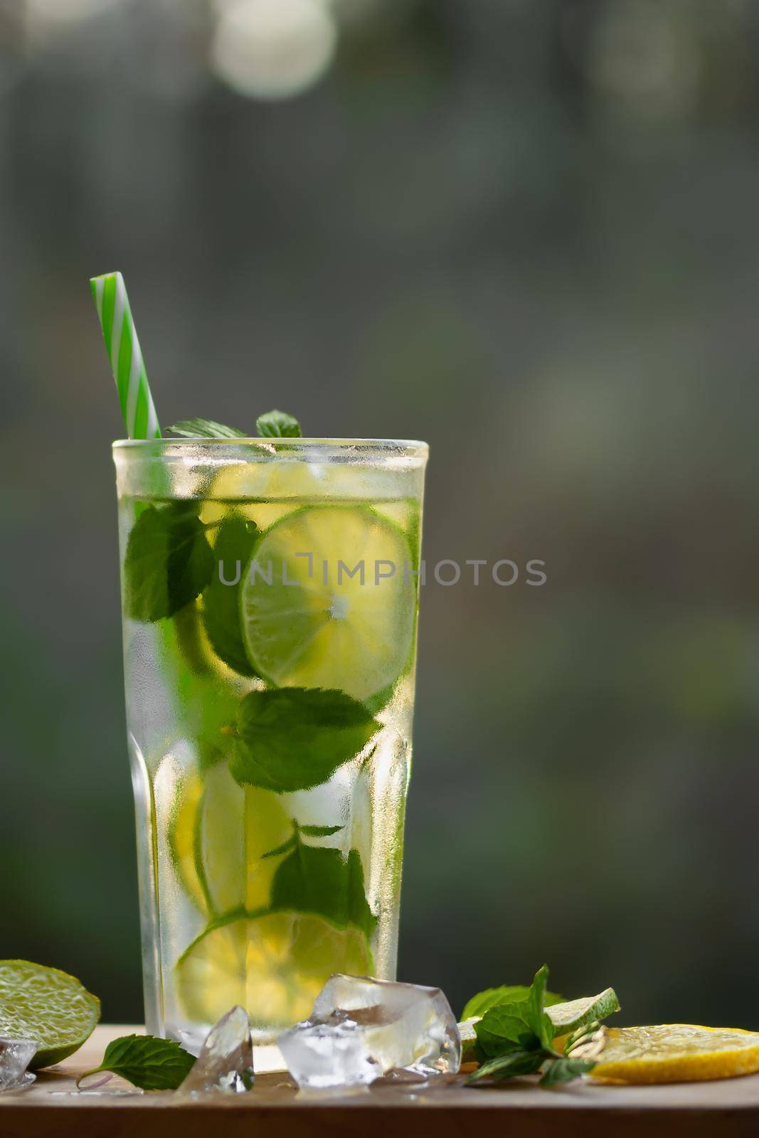 Cold refreshing homemade lemonade with mint, lemon and lime in a glass, copyspace, vertical image by galsand