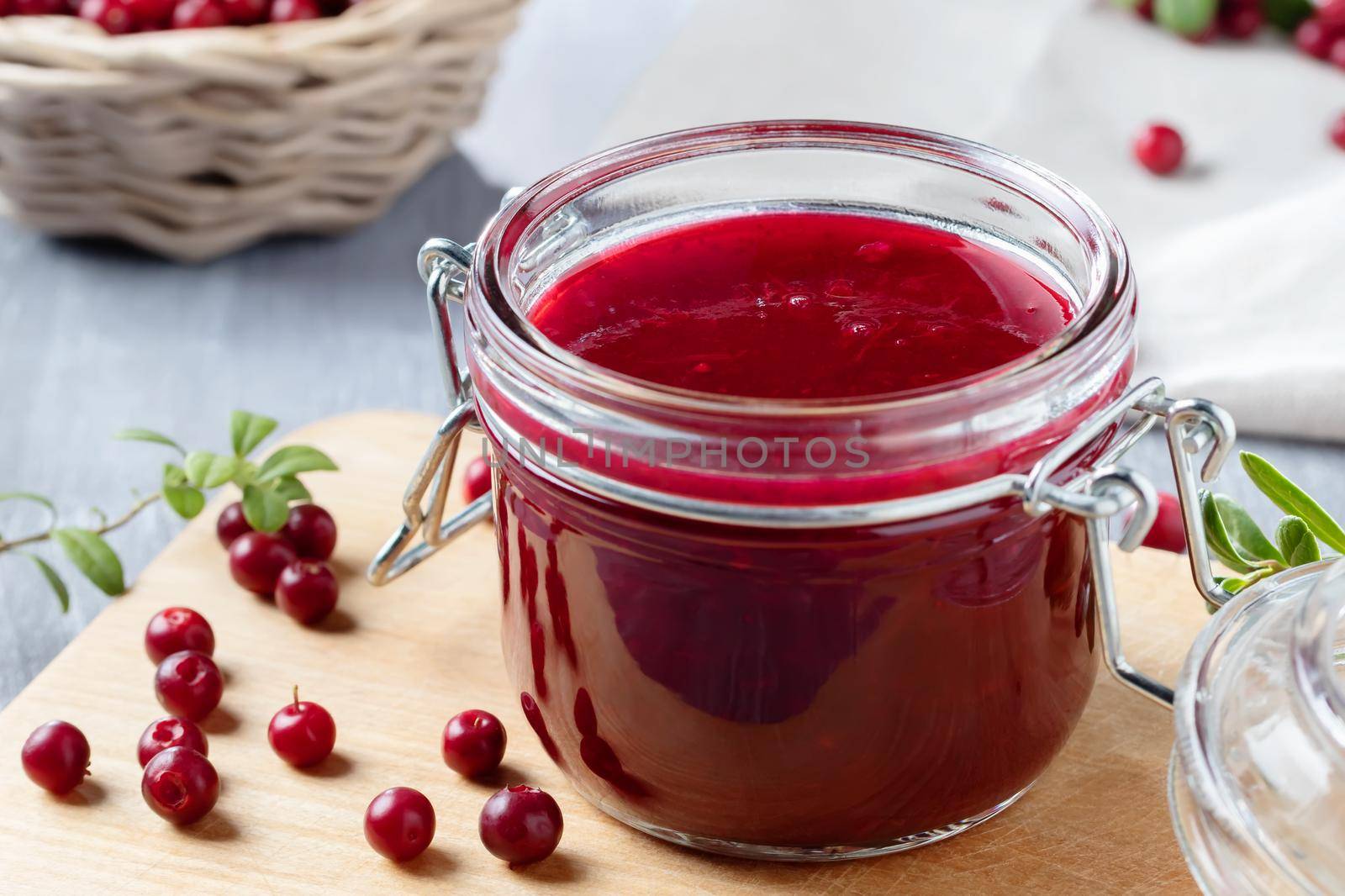 Glass jar with homemade lingonberry sauce. Canning lingonberry sauce.