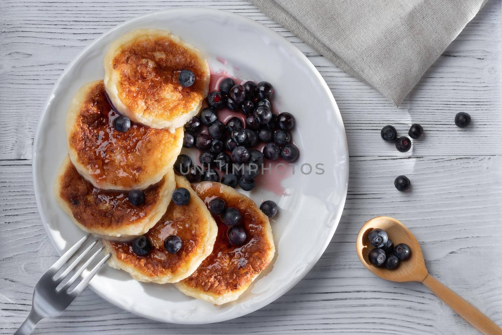 Fresh cottage pancakes with cheese and blueberries in syrup. Summer breakfast in the village. Top veiw.