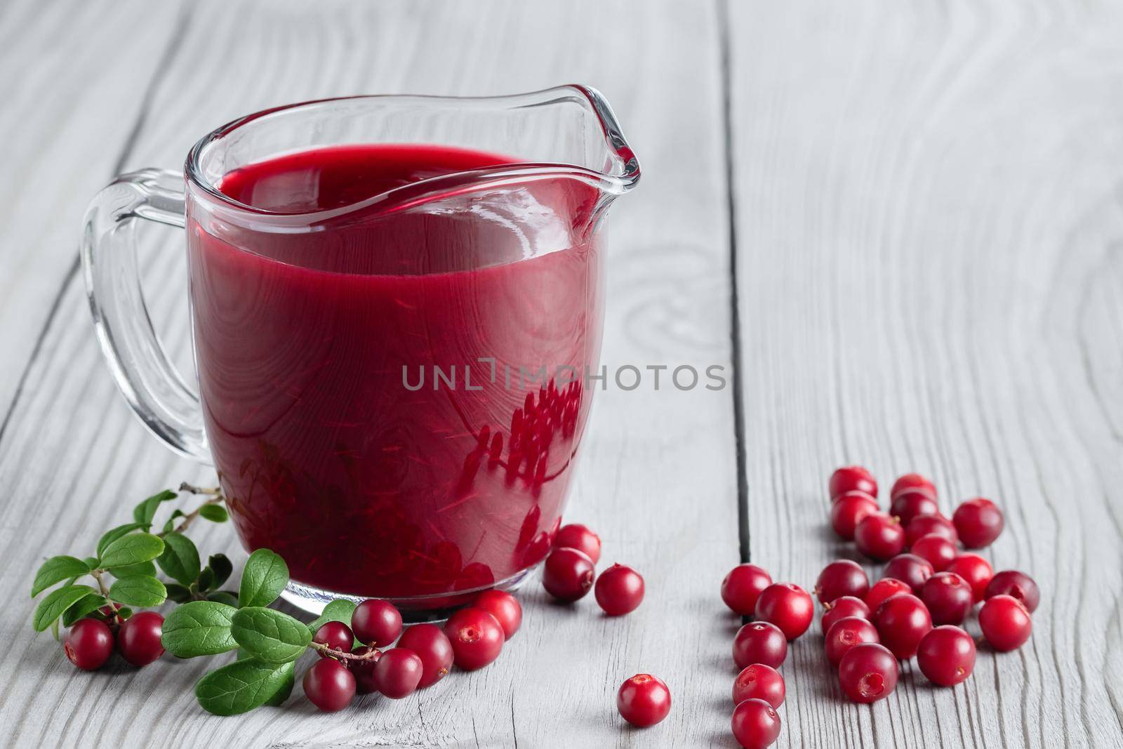 Homemade fresh wild lingonberry sauce in a glass gravy boat, copyspace by galsand