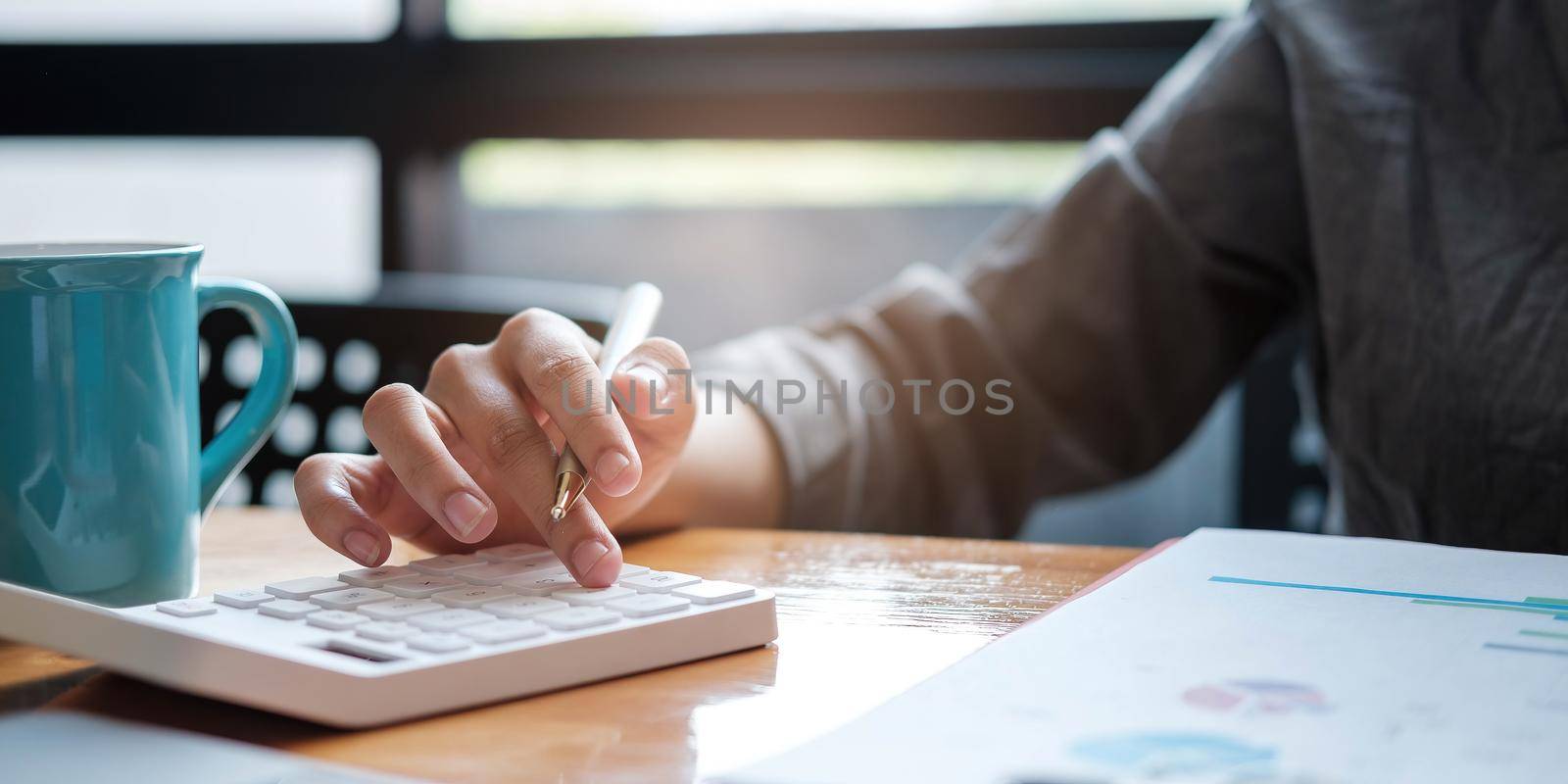 a businesswoman uses a laptop to calculate investment results. And making financial reports on the desk Business finance accounting concept by wichayada