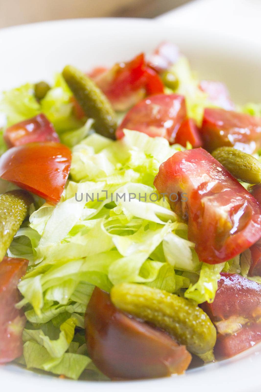 Lettuce salad with tomato and pickles. Raw food