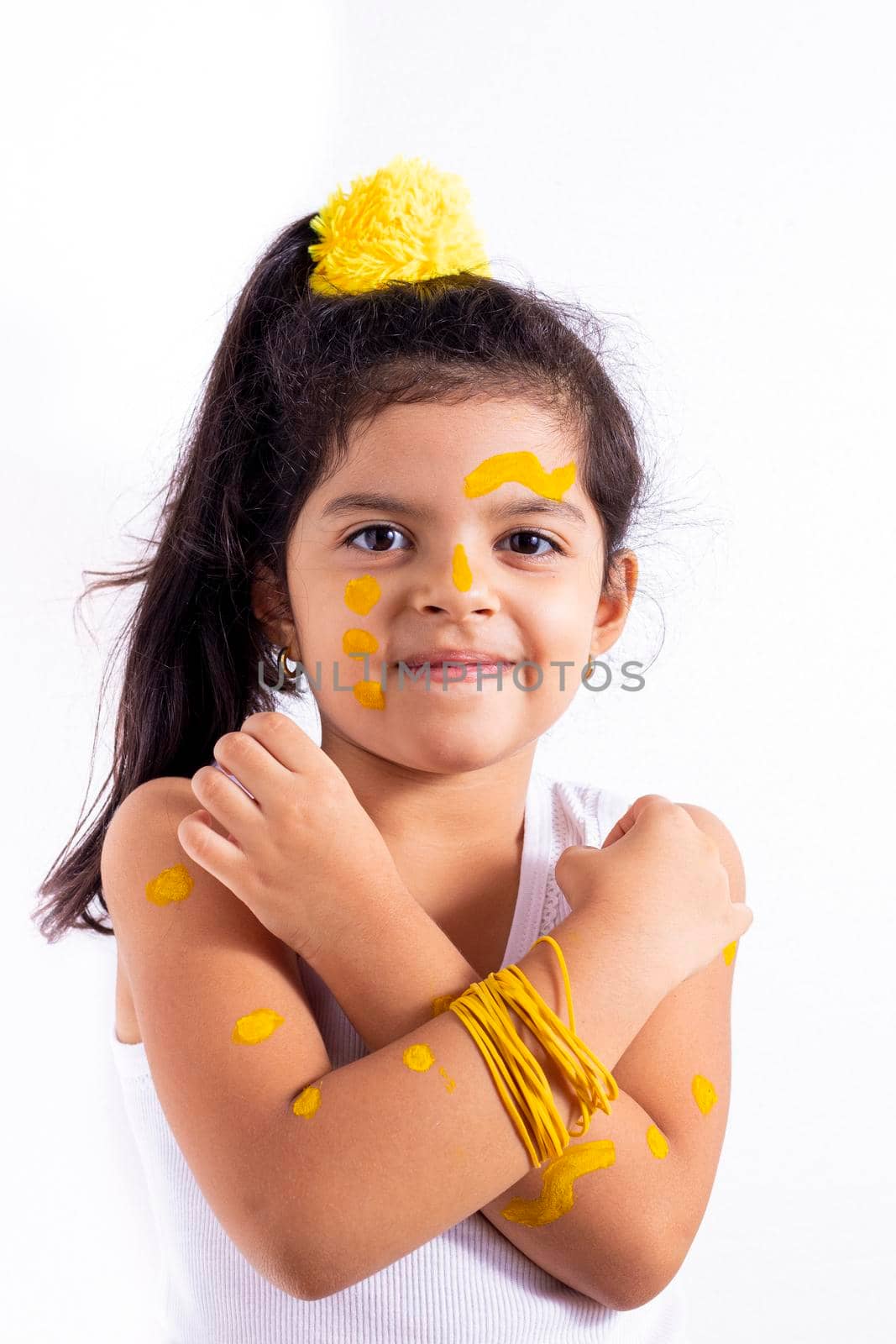 Happy little girl, with her face painted to celebrate the yellow day