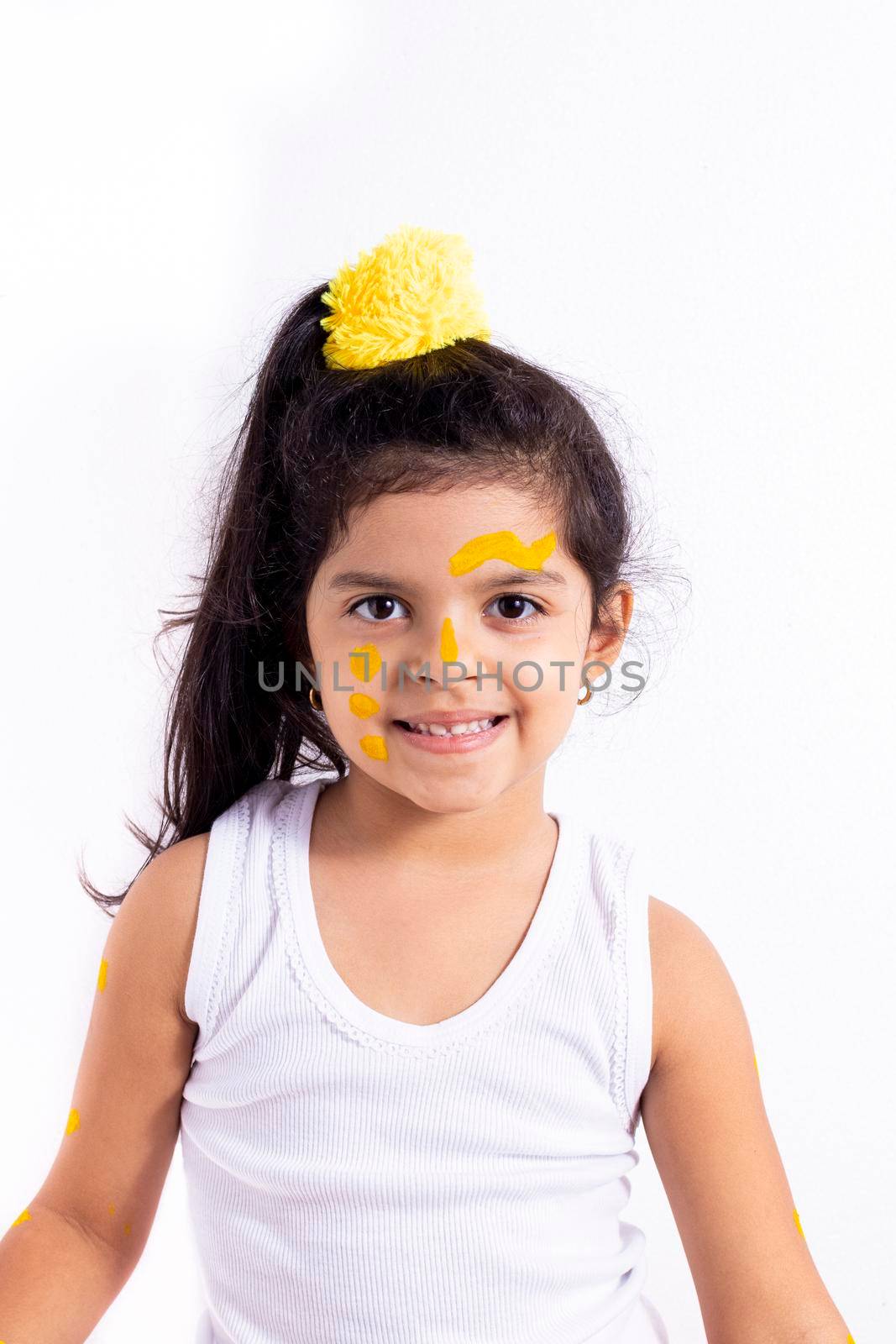 Happy little girl, with her face painted to celebrate the yellow day