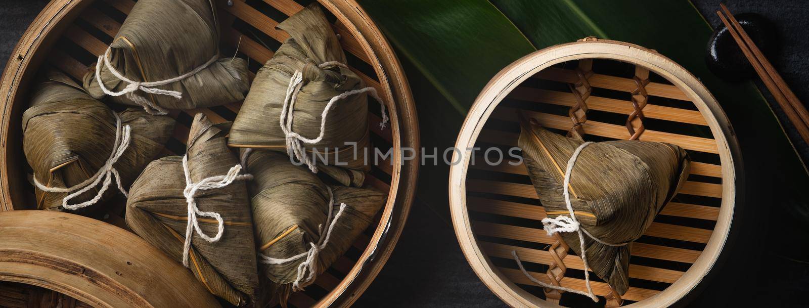 Zongzi Rice dumpling top view for Chinese traditional Dragon Boat Festival (Duanwu Festival) over dark black slate background.