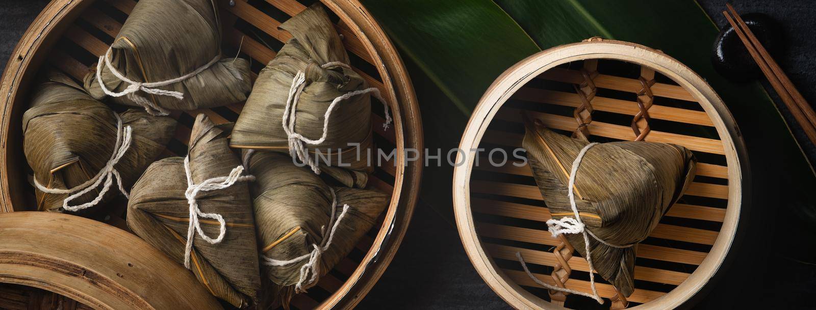 Zongzi Rice dumpling top view for Chinese traditional Dragon Boat Festival (Duanwu Festival) over dark black slate background.