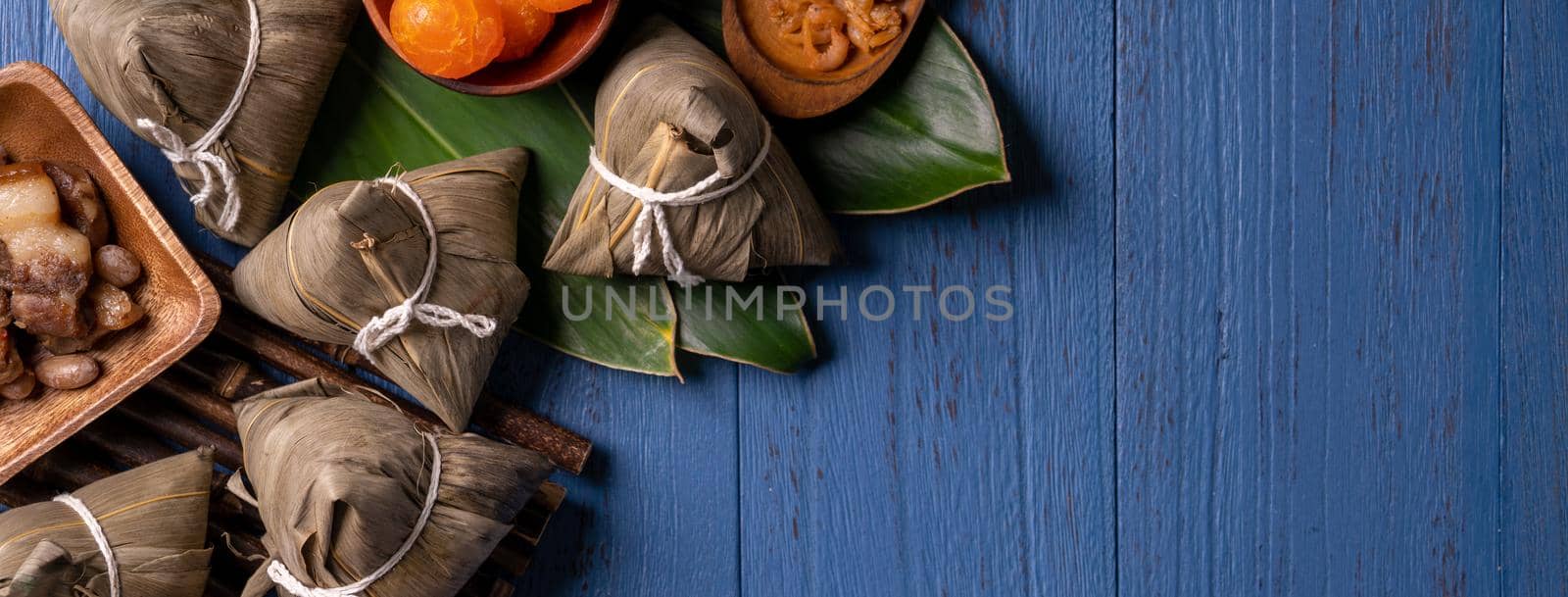 Zongzi rice dumpling with ingredients top view for Chinese traditional Dragon Boat Festival (Duanwu Festival) over blue wooden table background.