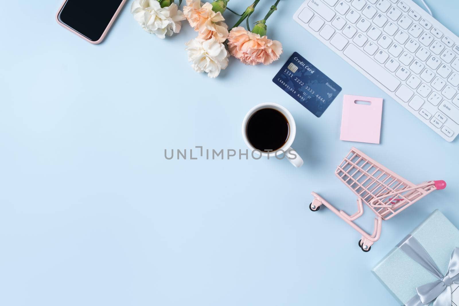 Mother's day buying gift design concept with carnation flower on office blue table desk background.