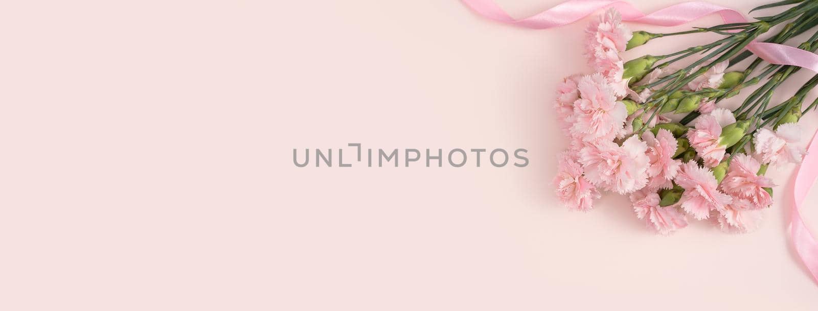 Design concept of Mother's day holiday greeting design with carnation bouquet on pastel pink table background