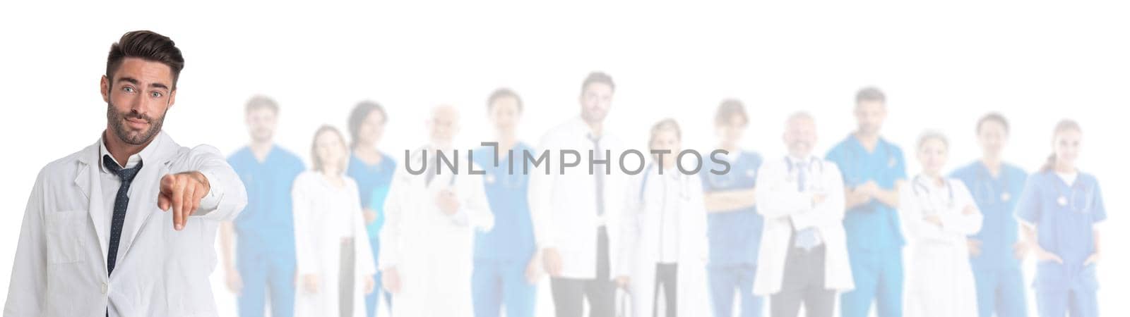 Healthcare and medical concept - attractive male doctor in front of medical group pointing at you studio isolated on white background