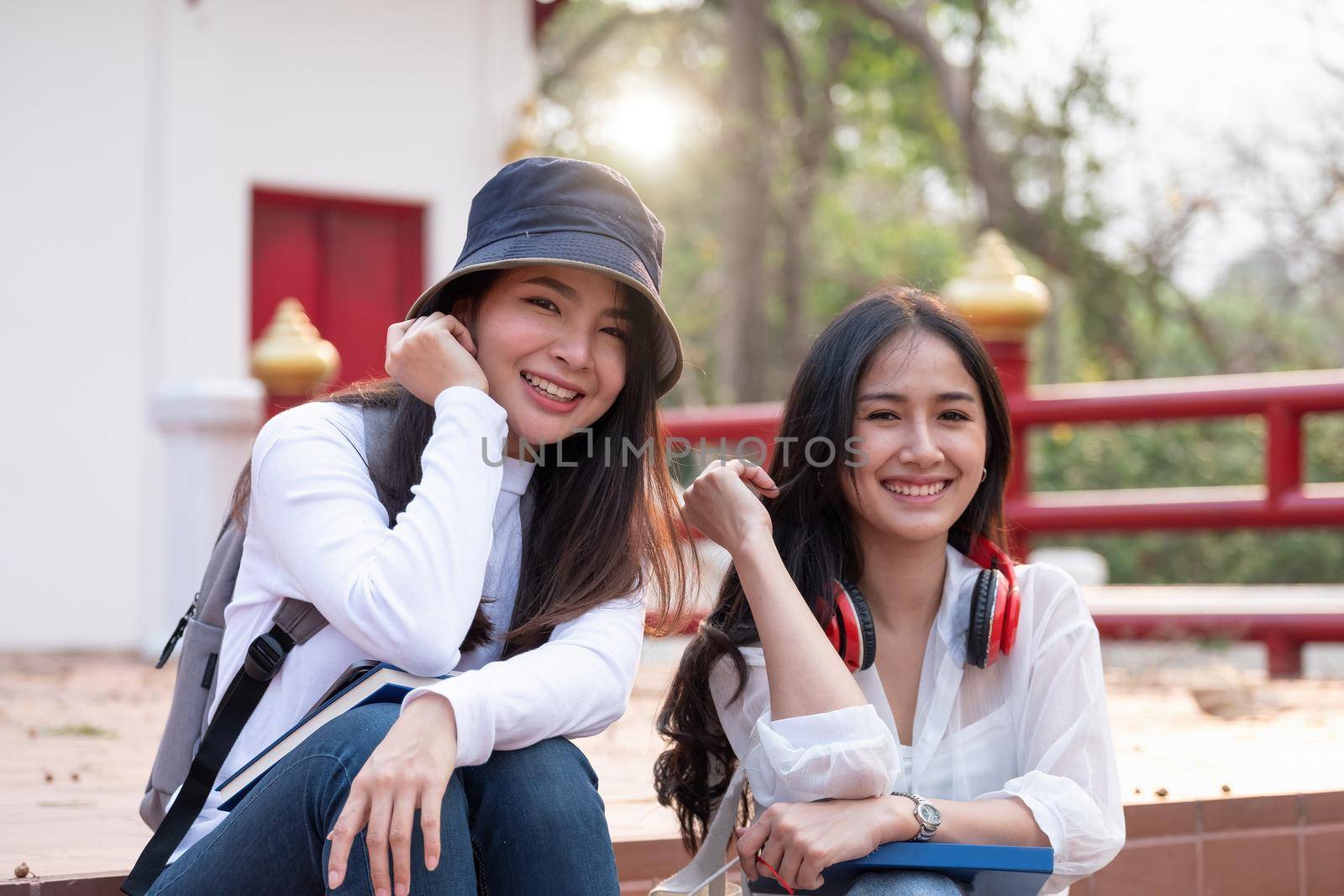 Portrait of two asian happy teen high school students outdoors
