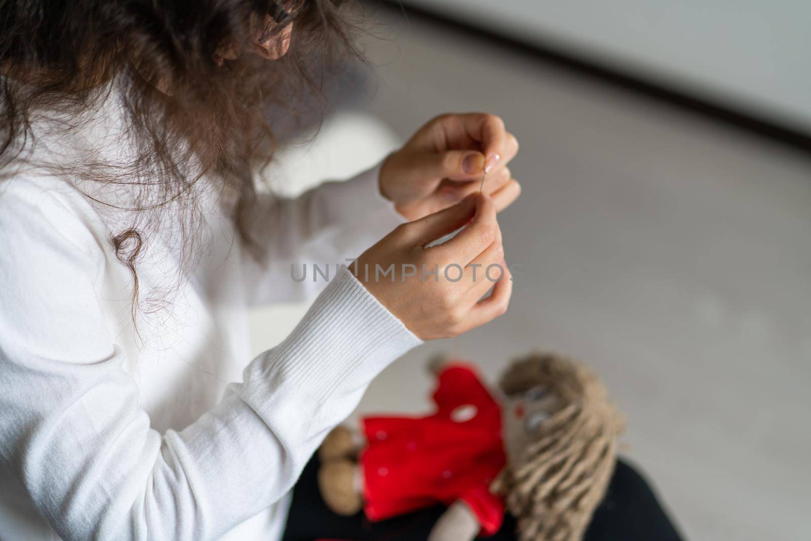 Handicraft is a fascinating hobby. The person sews dolls at their leisure.