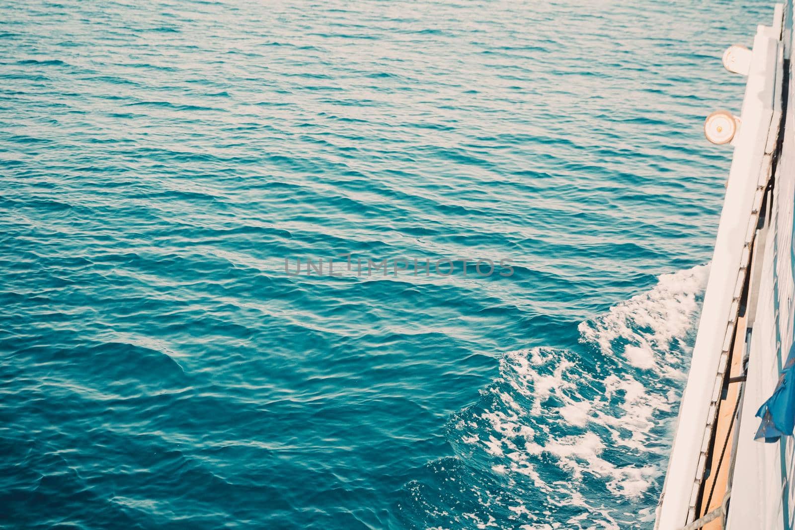 Beach, travel and environment concept. Ocean water surface texture, vintage summer background made of blue water.waves from a boat with sea foam.