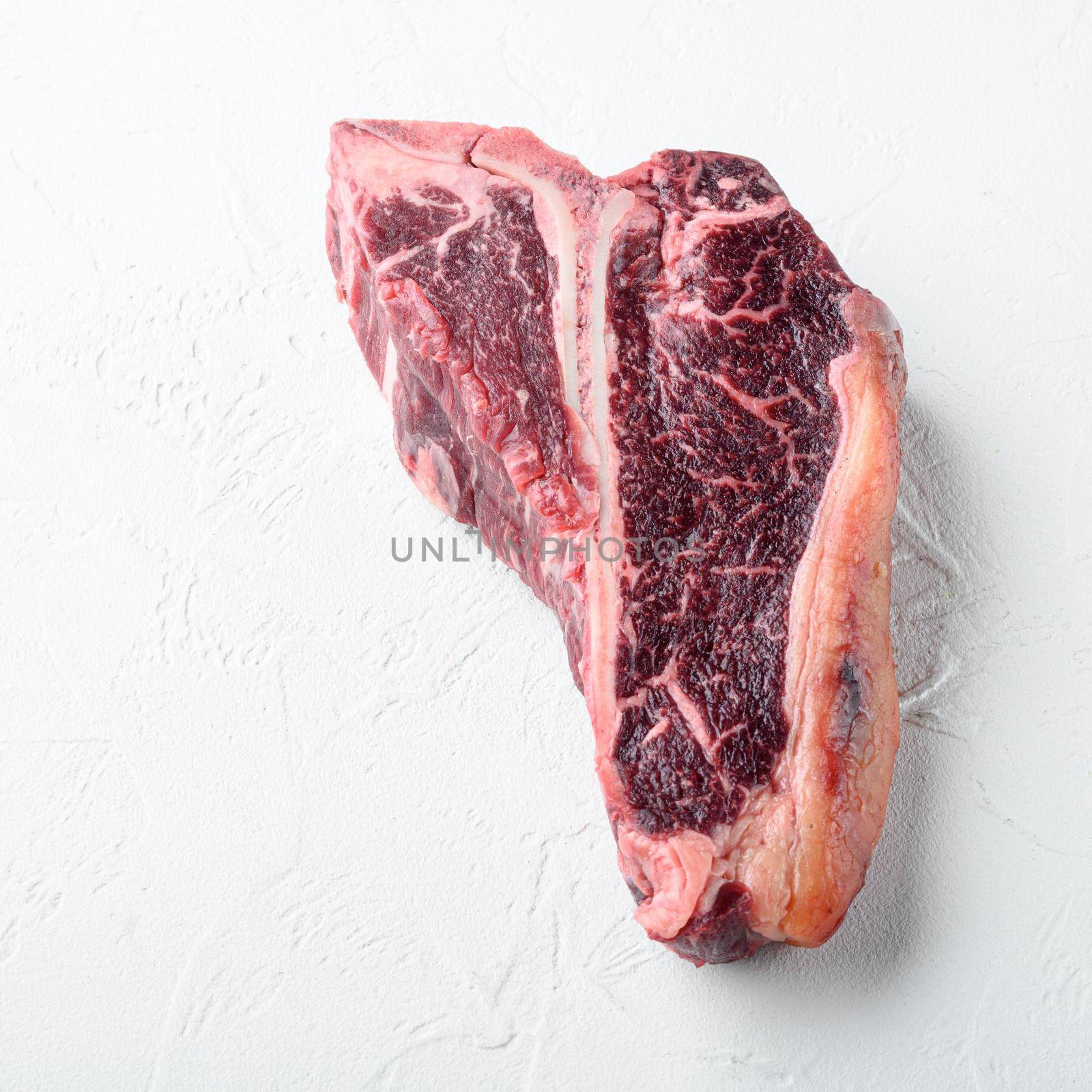 Italian Florentine T bone dry aged beef meat Steak, on white stone background, square format by Ilianesolenyi