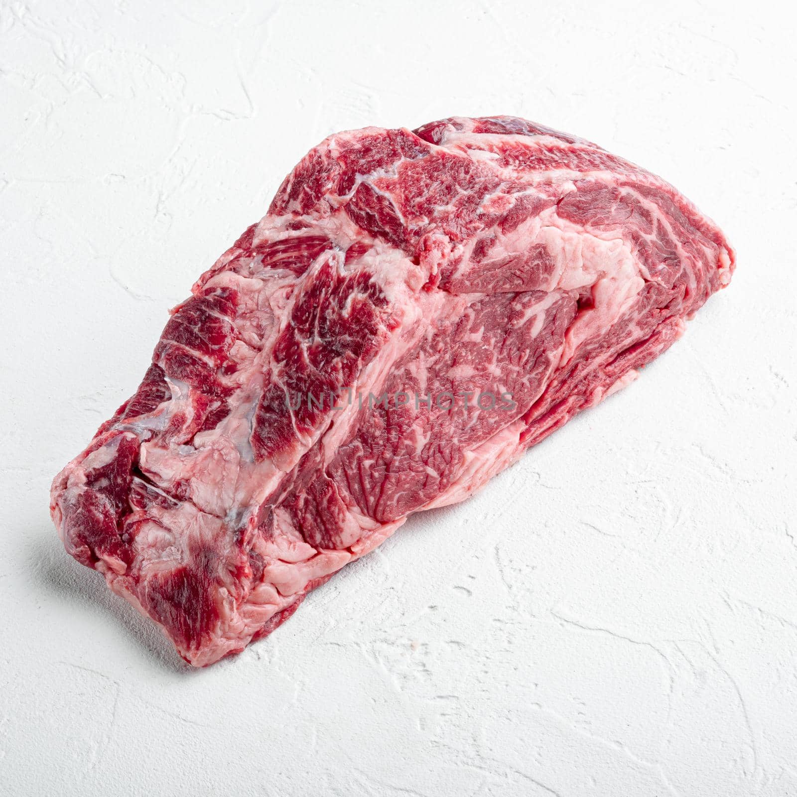 Raw Marble beef black Angus, ribeye or scotch fillet, square format, on white stone background by Ilianesolenyi