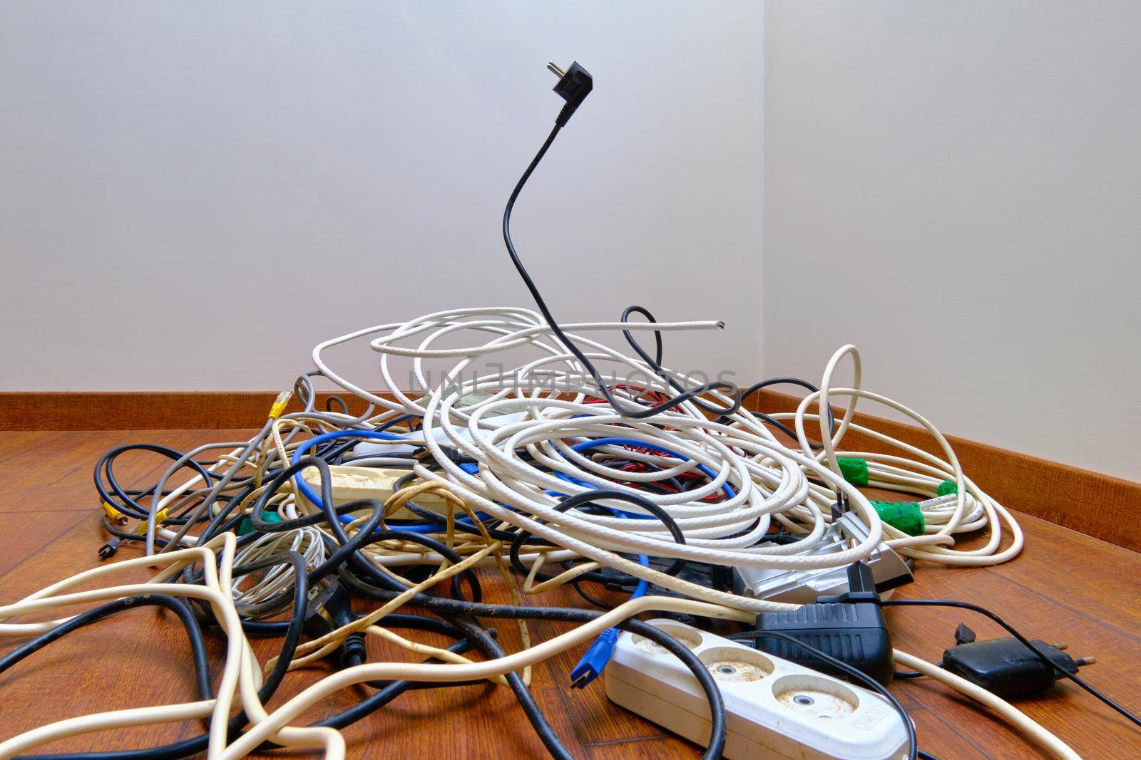 A tangled tangle of unnecessary wires lies on the floor.