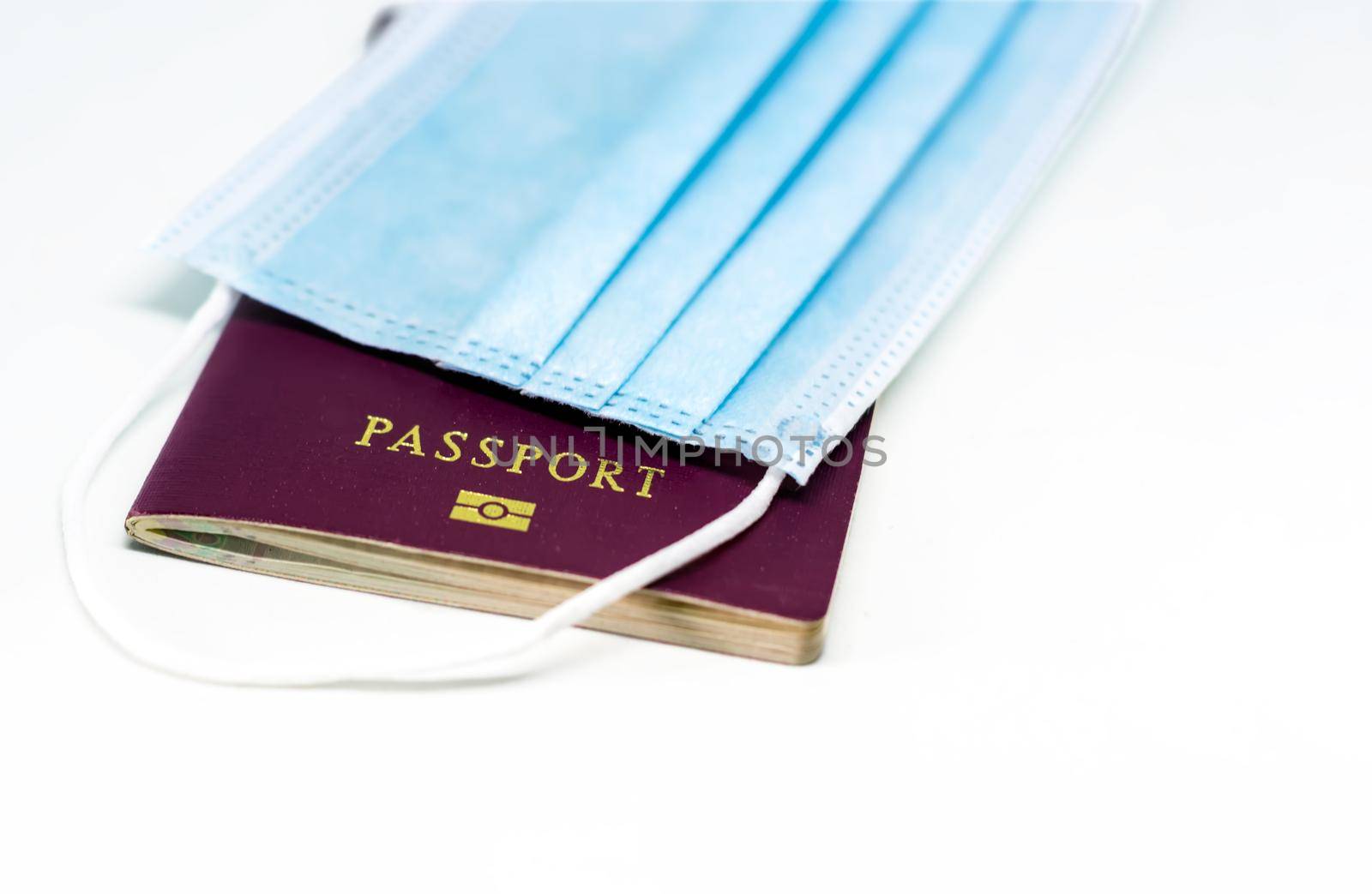 Surgical face mask over a passport. Traveling during the Covid 19 coronavirus pandemic. Virus protection and prevention measures. Travel restrictions