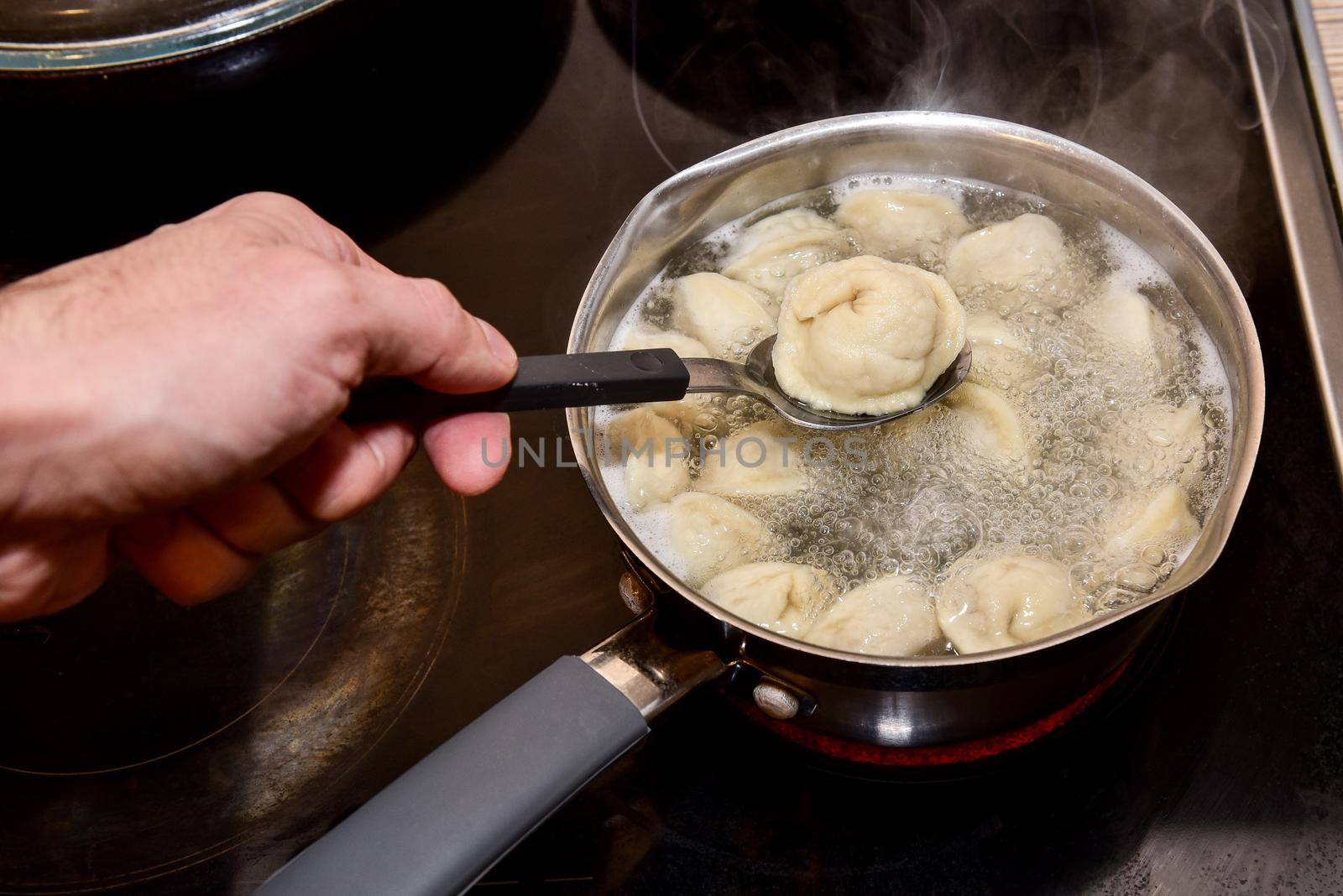 Dumplings in boiling water. Meat dumplings are boiled in a pot of boiling water.