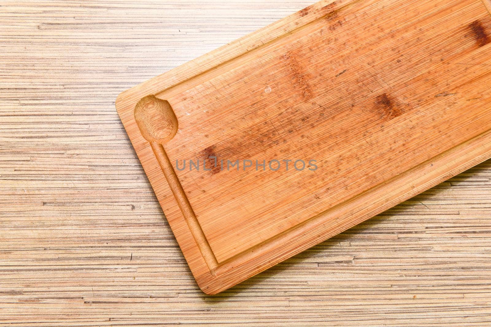 Old chopping board on wooden background top view.