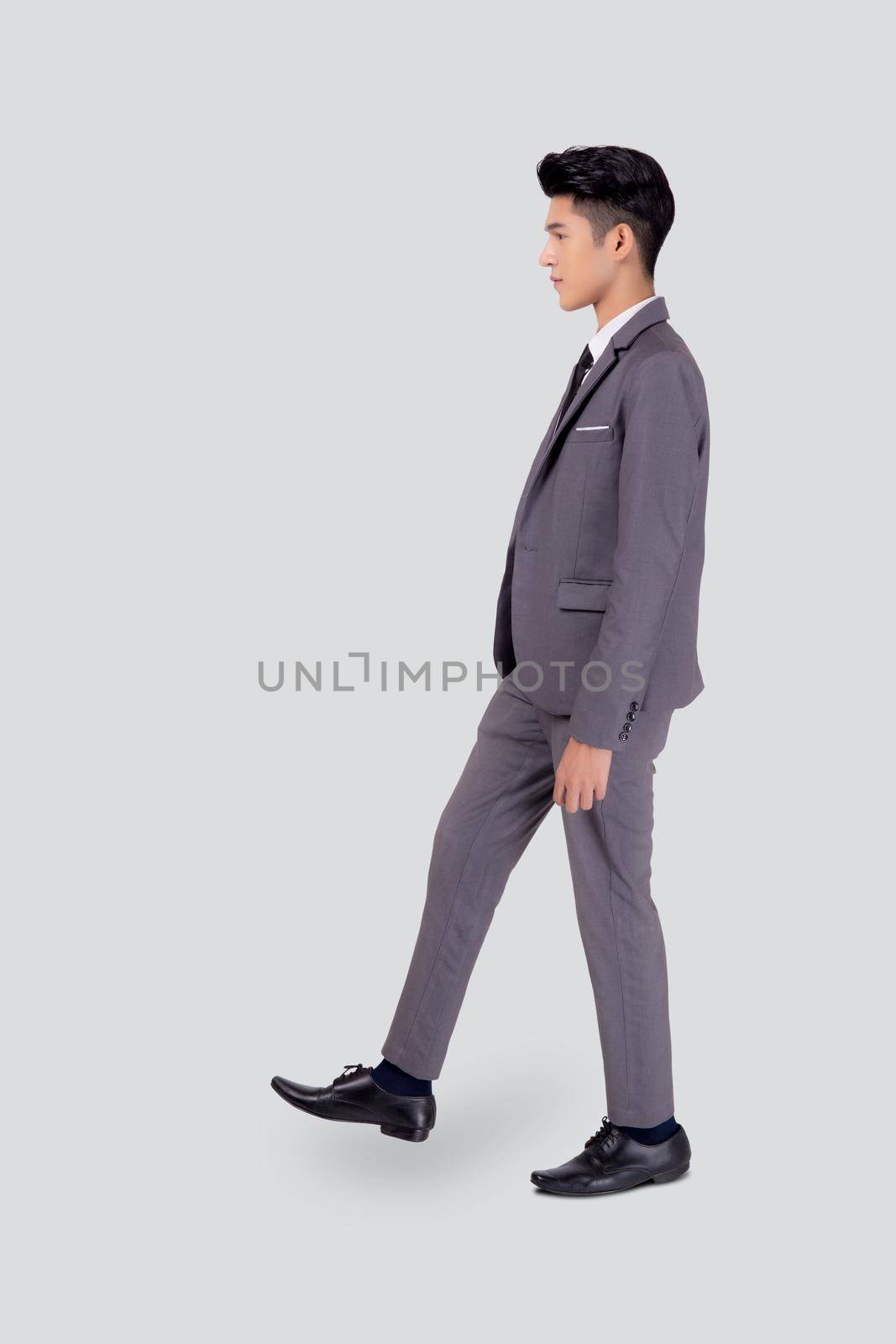 Young asian business man in suit walking movement isolated on white background, portrait of executive or manager, happy businessman handsome and smart, male with confident for success in studio. by nnudoo