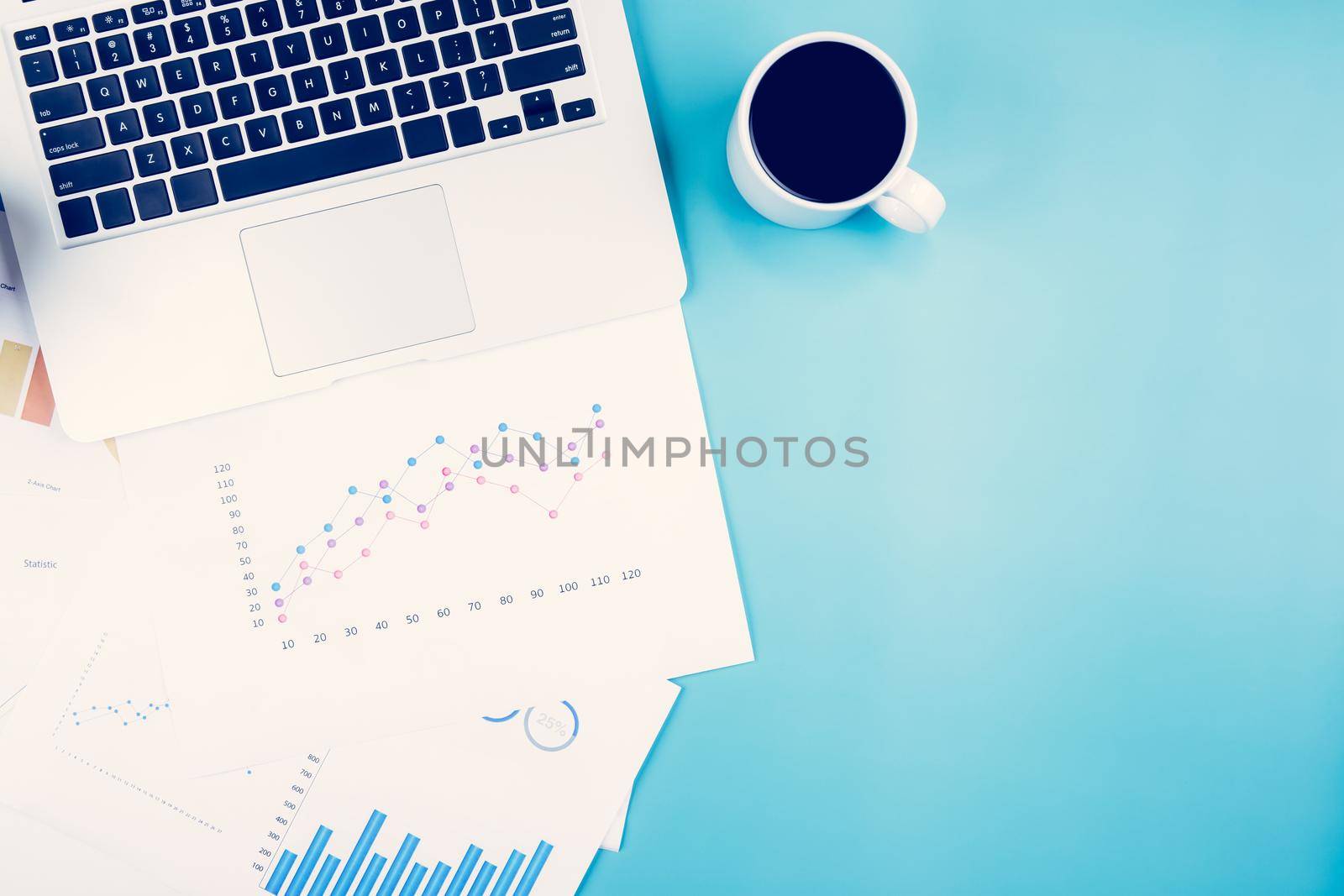 Laptop computer and documents report statistic financial with graph and chart and coffee on desk, finance and invest, digital marketing and growth of revenue, business and communication concept.
