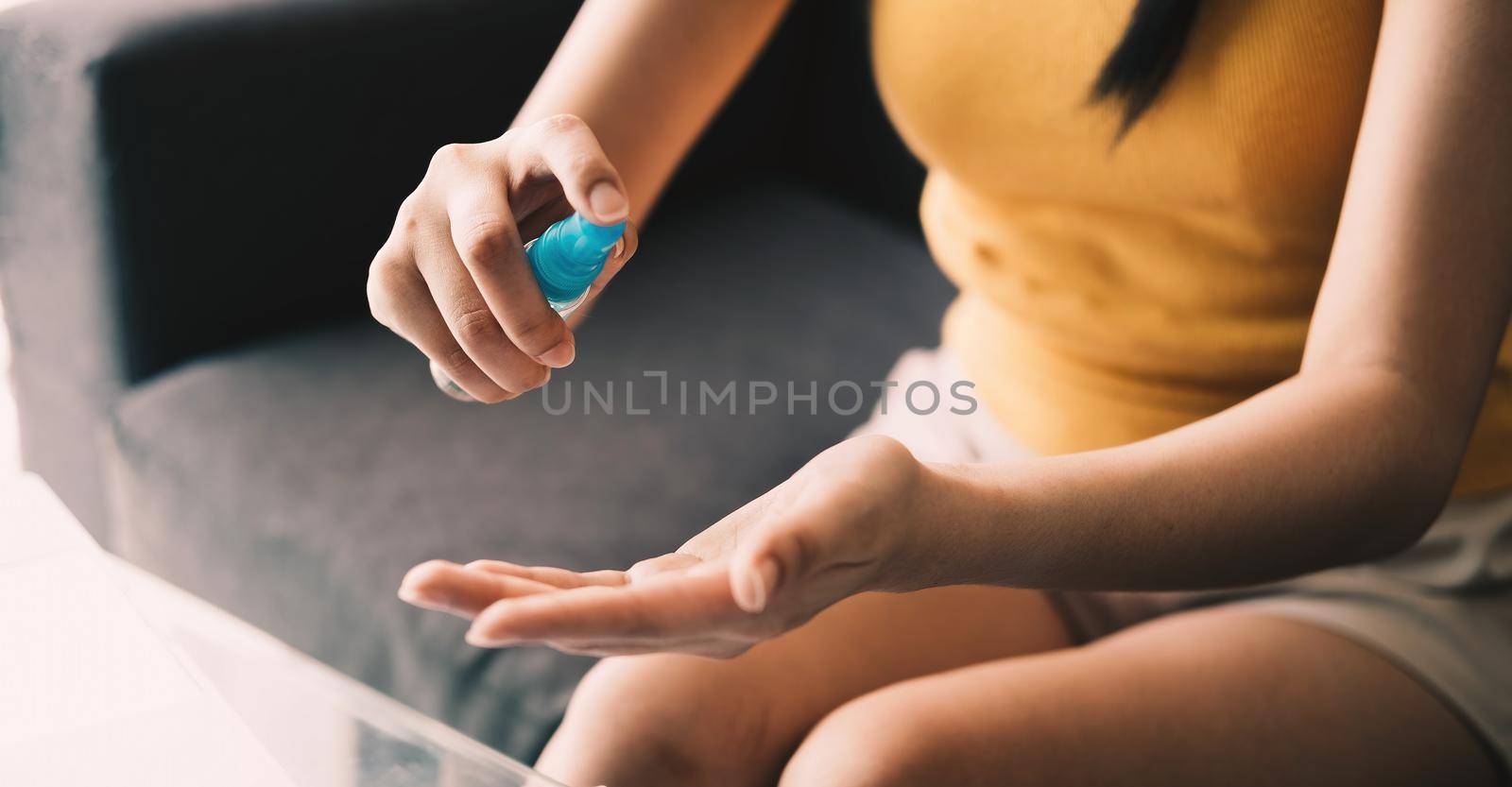 Close up hand of lady that applying alcohol spray or anti-bacteria spray to prevent the spread of germs, bacteria and virus. Personal hygiene concept.