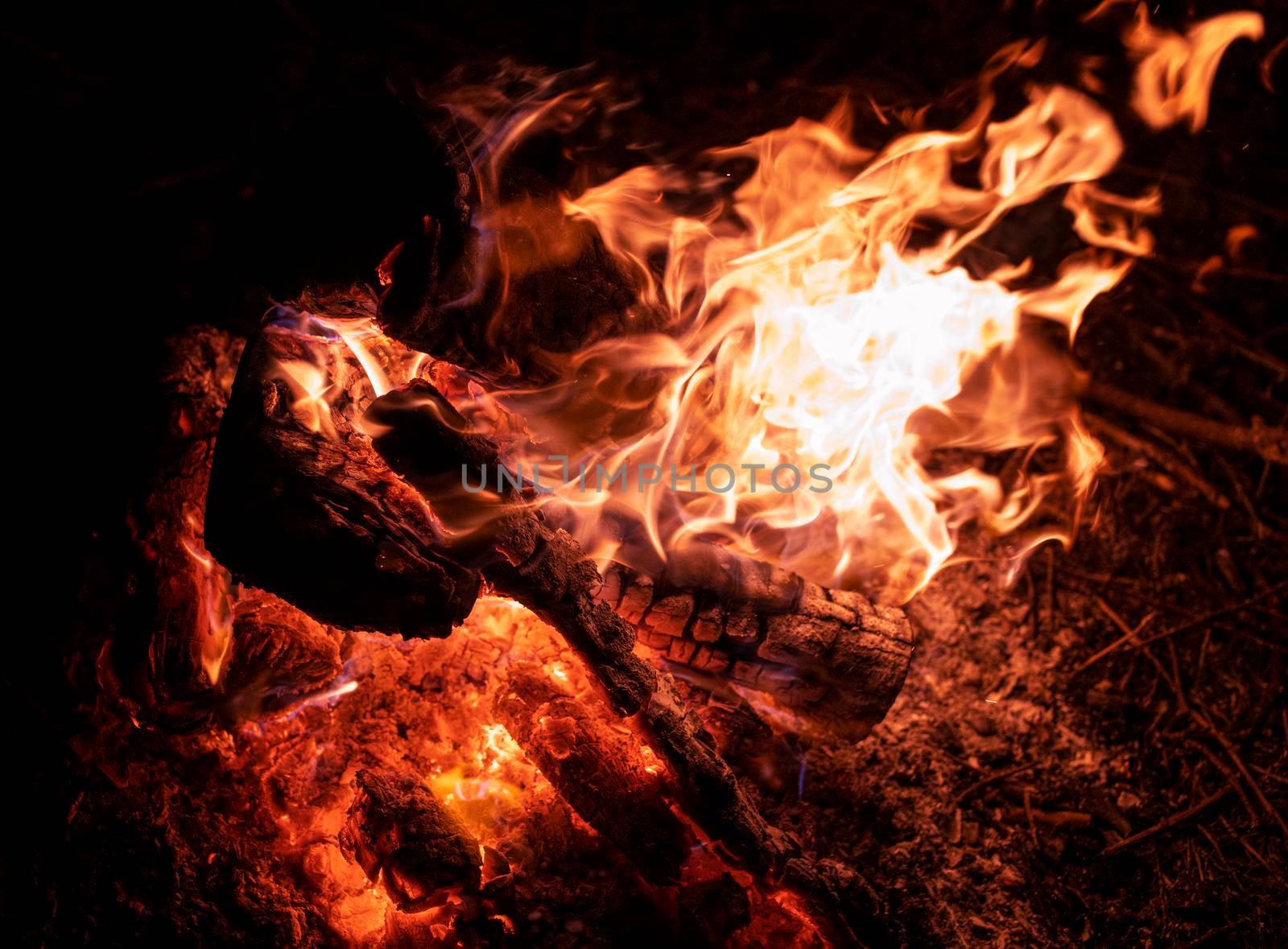 Beautiful camping fire burning outdoors with lots of glowing embers.