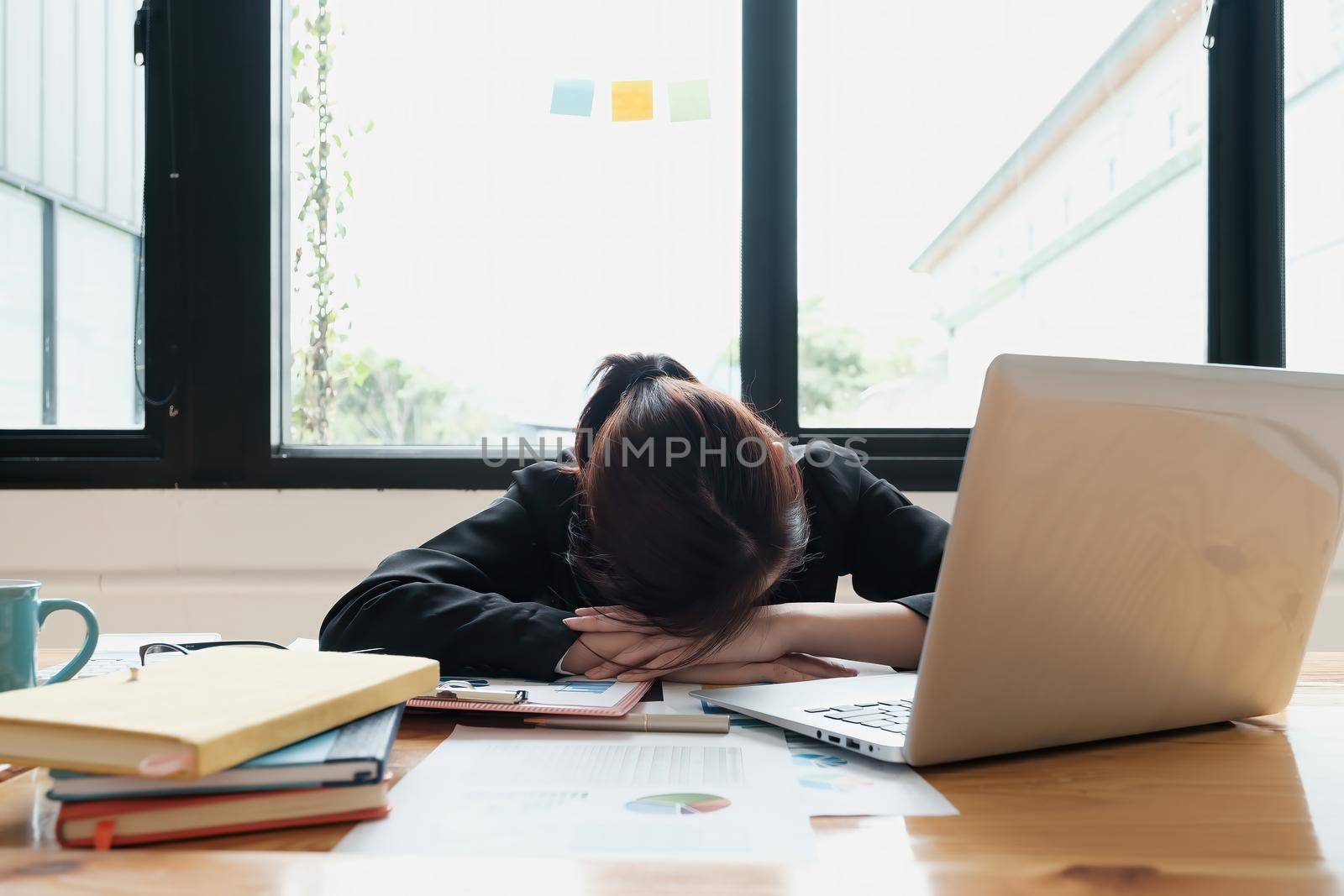Stressed business woman hard working until morning and tired and sleep at table in office while project deadlines. finance, account, tax, audit concept. by itchaznong