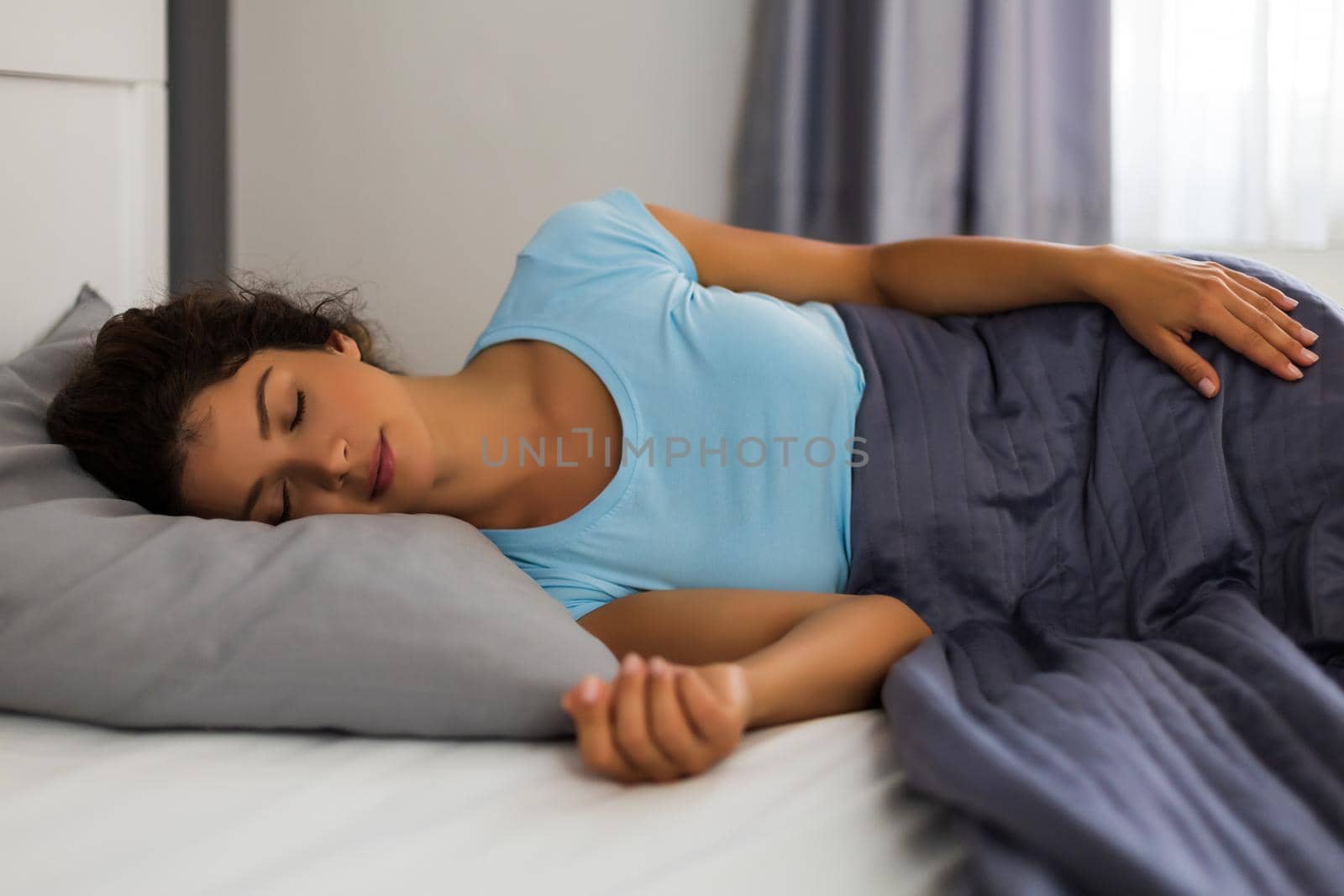 Beautiful woman in pajamas enjoys sleeping in bedroom.