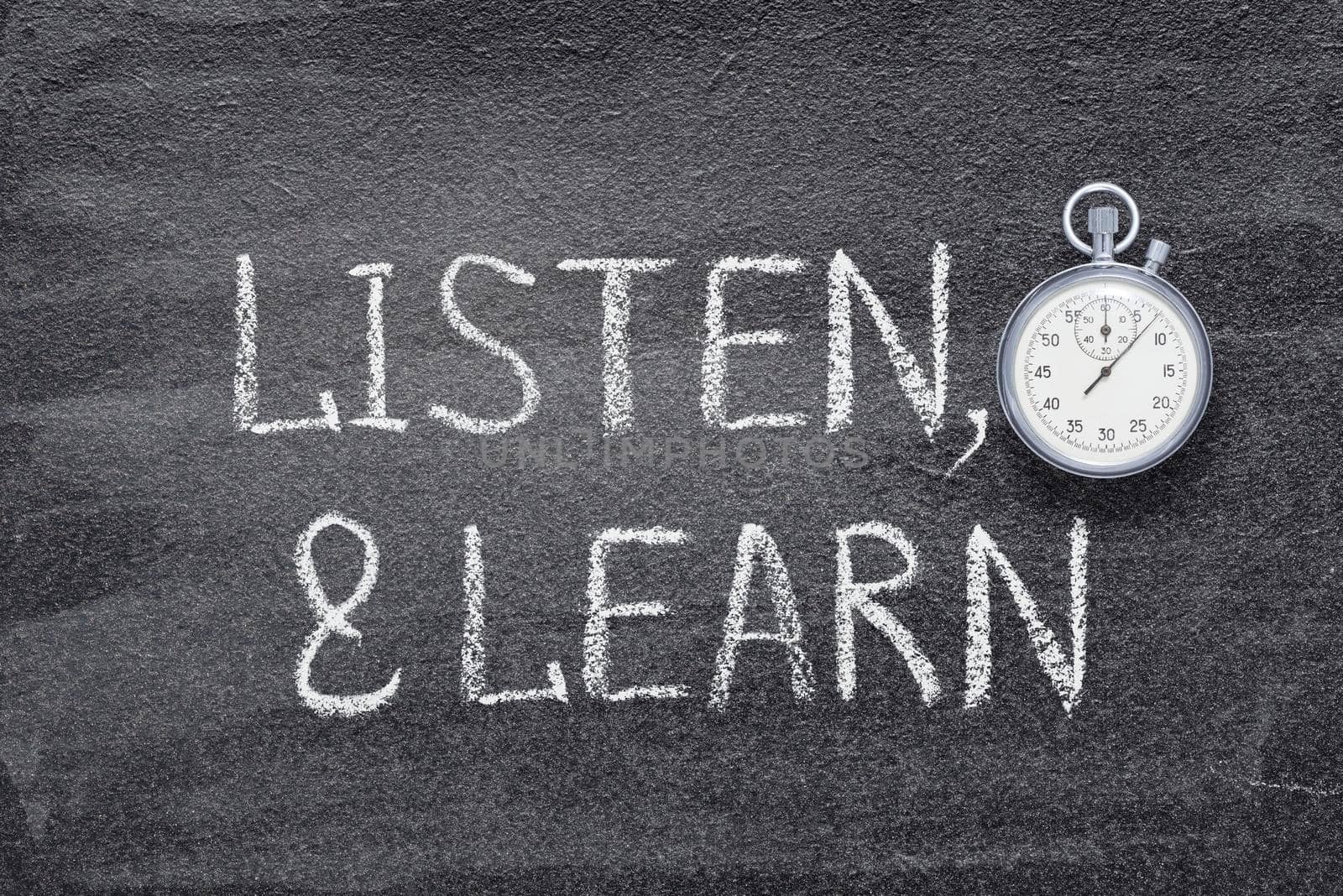 listen and learn phrase written on chalkboard with vintage precise stopwatch 
