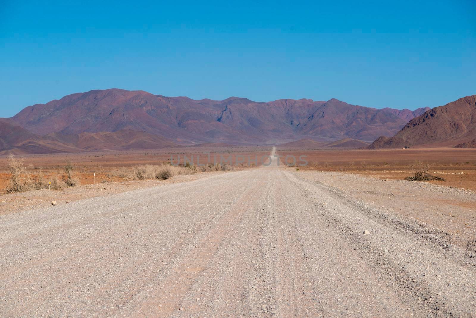 empty gravel road in desert by sunny day in Namibia