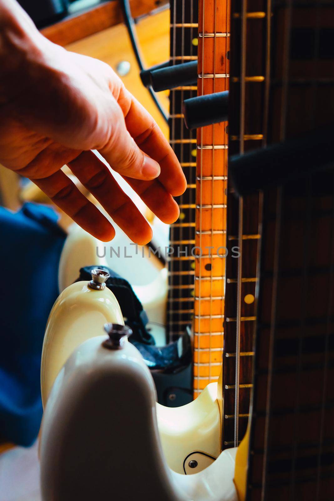close up Image of Hand picking up guitar