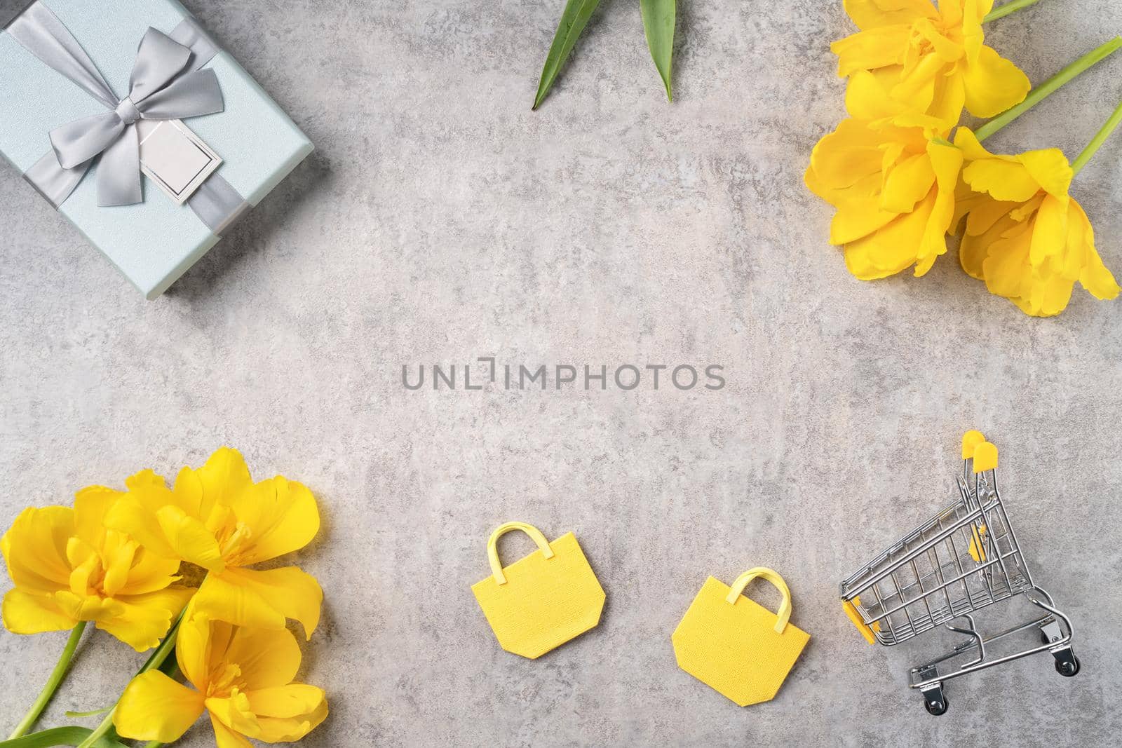 Concept of Mother's day holiday gift shopping greeting design with yellow tulip flower bouquet on gray background