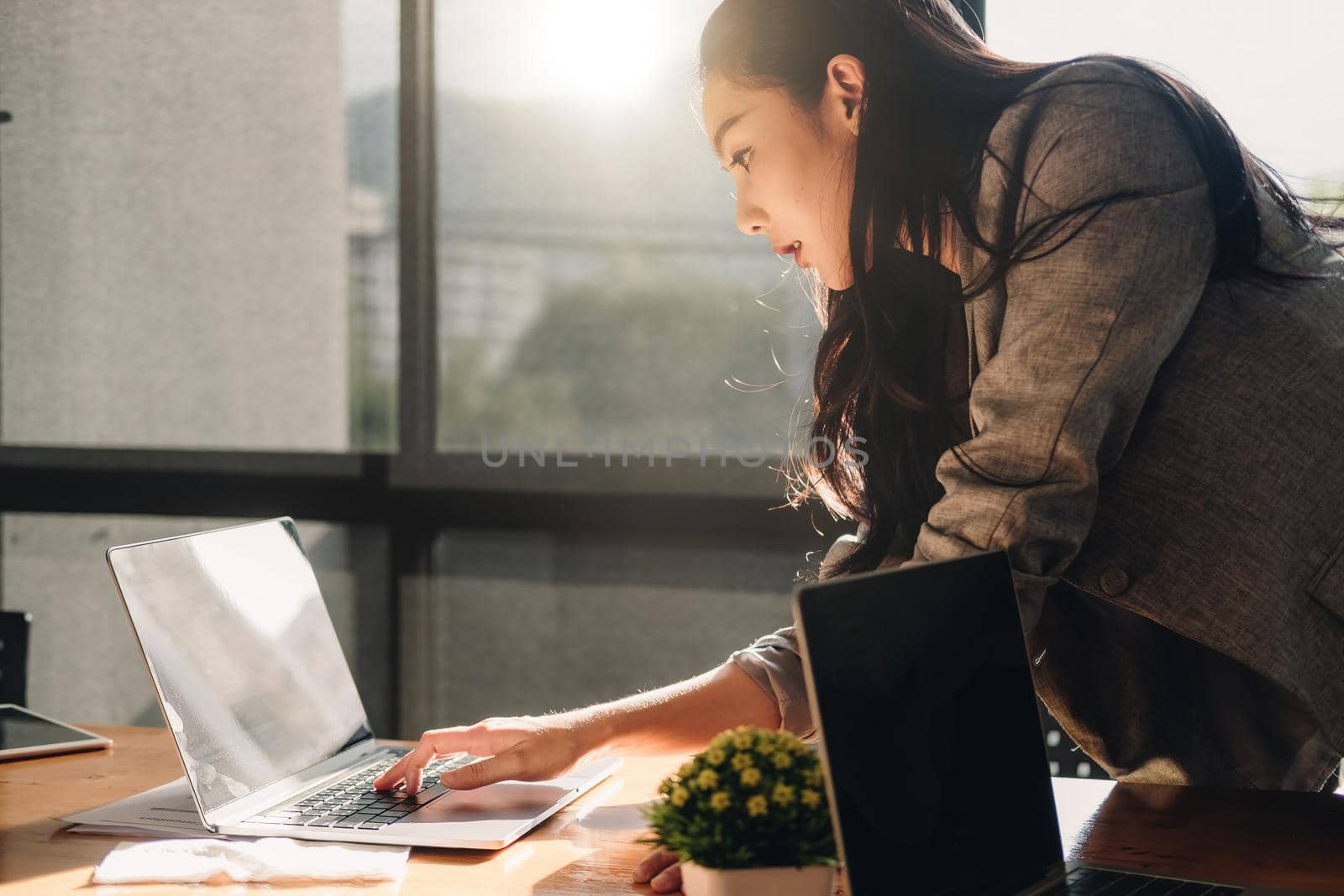 Attractive asian woman usiing laptop computer at her office by nateemee