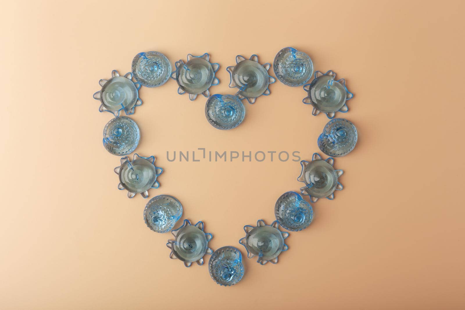 Top view of heart made of blue sea shells against light beige background. Concept of summer vacations and beach by Senorina_Irina