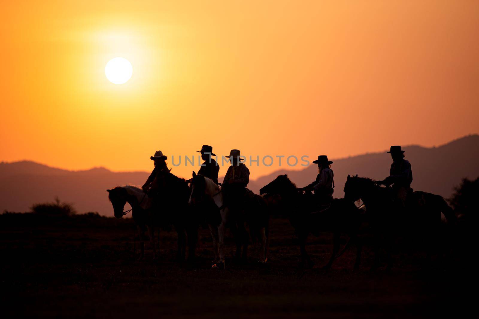 cowboy on horseback against a beautiful sunset, cowboy and horse at first light,mountain, river and lifestyle with natural light background	
