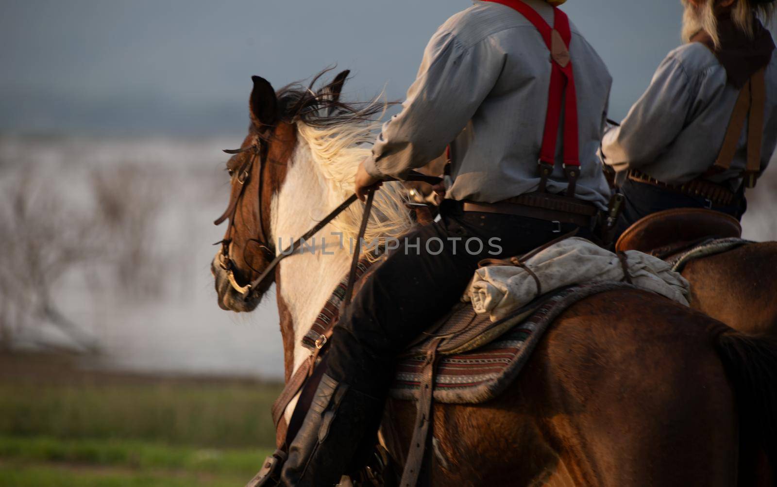cowboy on horseback against a beautiful sunset, cowboy and horse at first light,mountain, river and lifestyle with natural light background	
