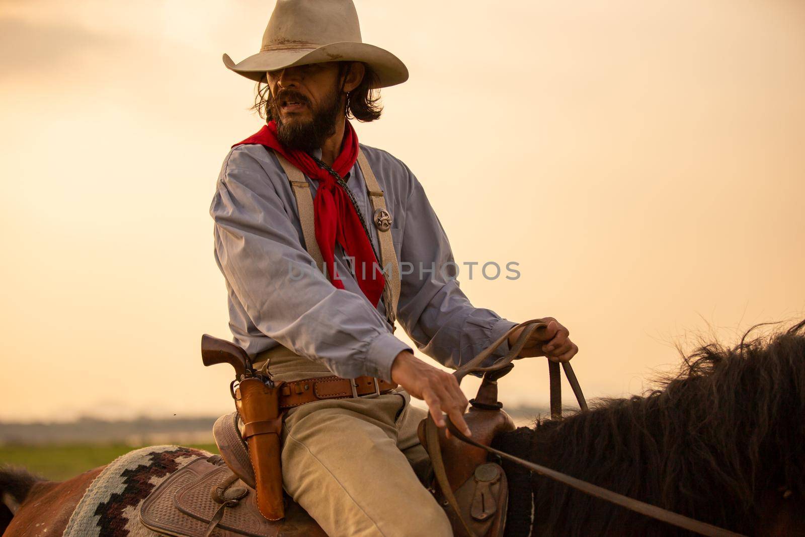 cowboy on horseback against a beautiful sunset, cowboy and horse at first light,mountain, river and lifestyle with natural light background	
 by chuanchai