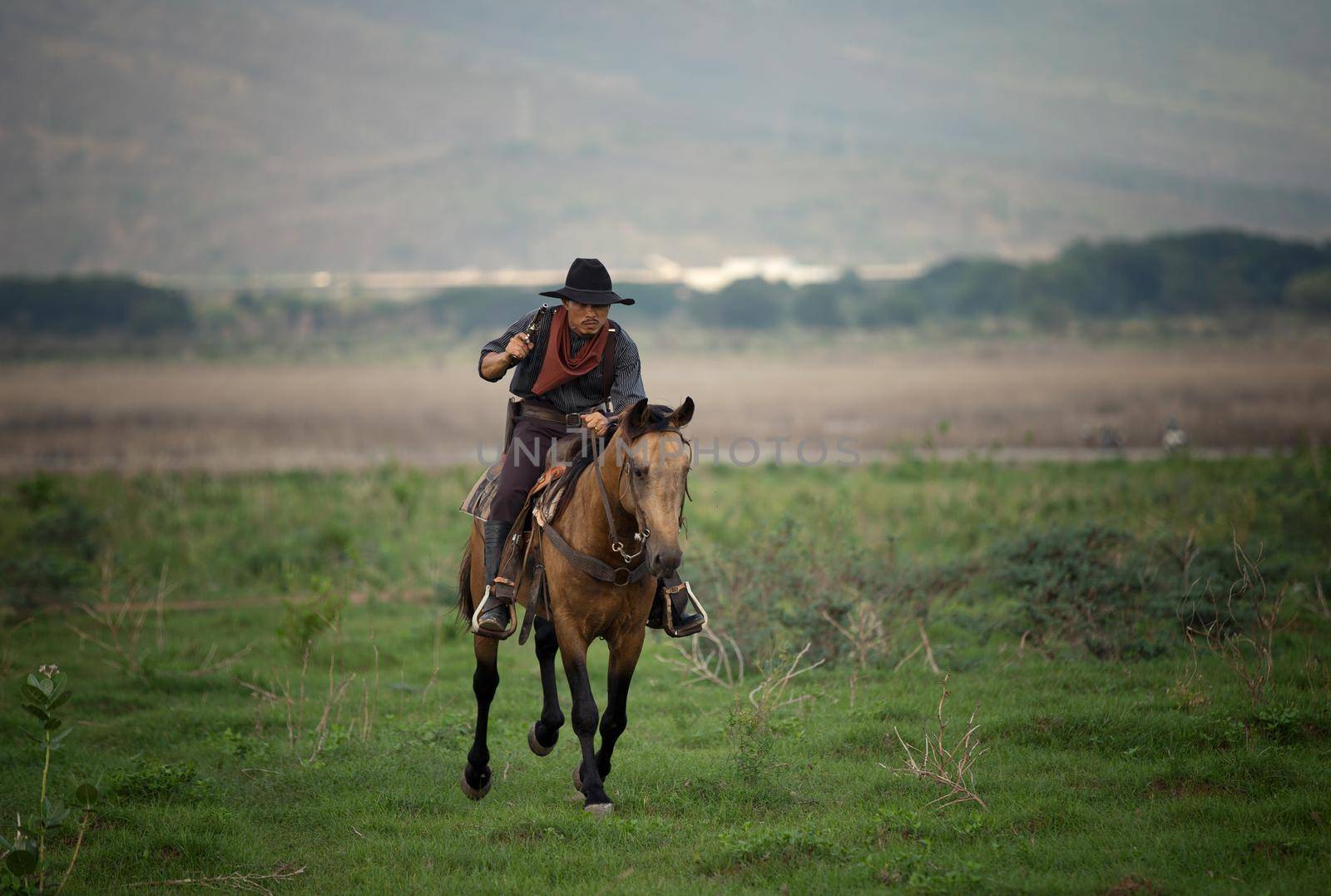 cowboy on horseback against a beautiful sunset, cowboy and horse at first light,mountain, river and lifestyle with natural light background	
