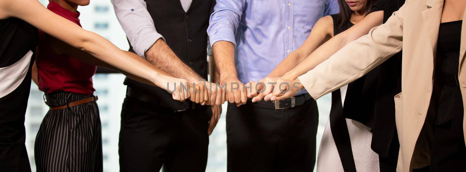 Close up on hands of business people join together on unity concept by chuanchai