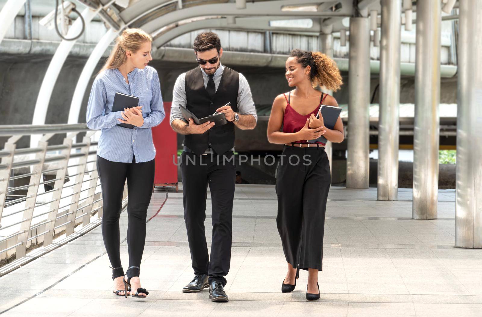Candid Portraits of business people discussing while walking on walkway.