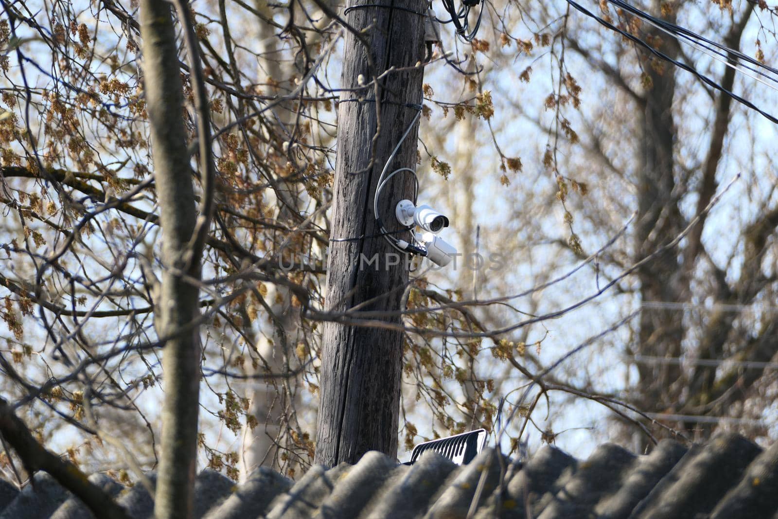 Outdoor security camera on a pole in the open air. by Olga26