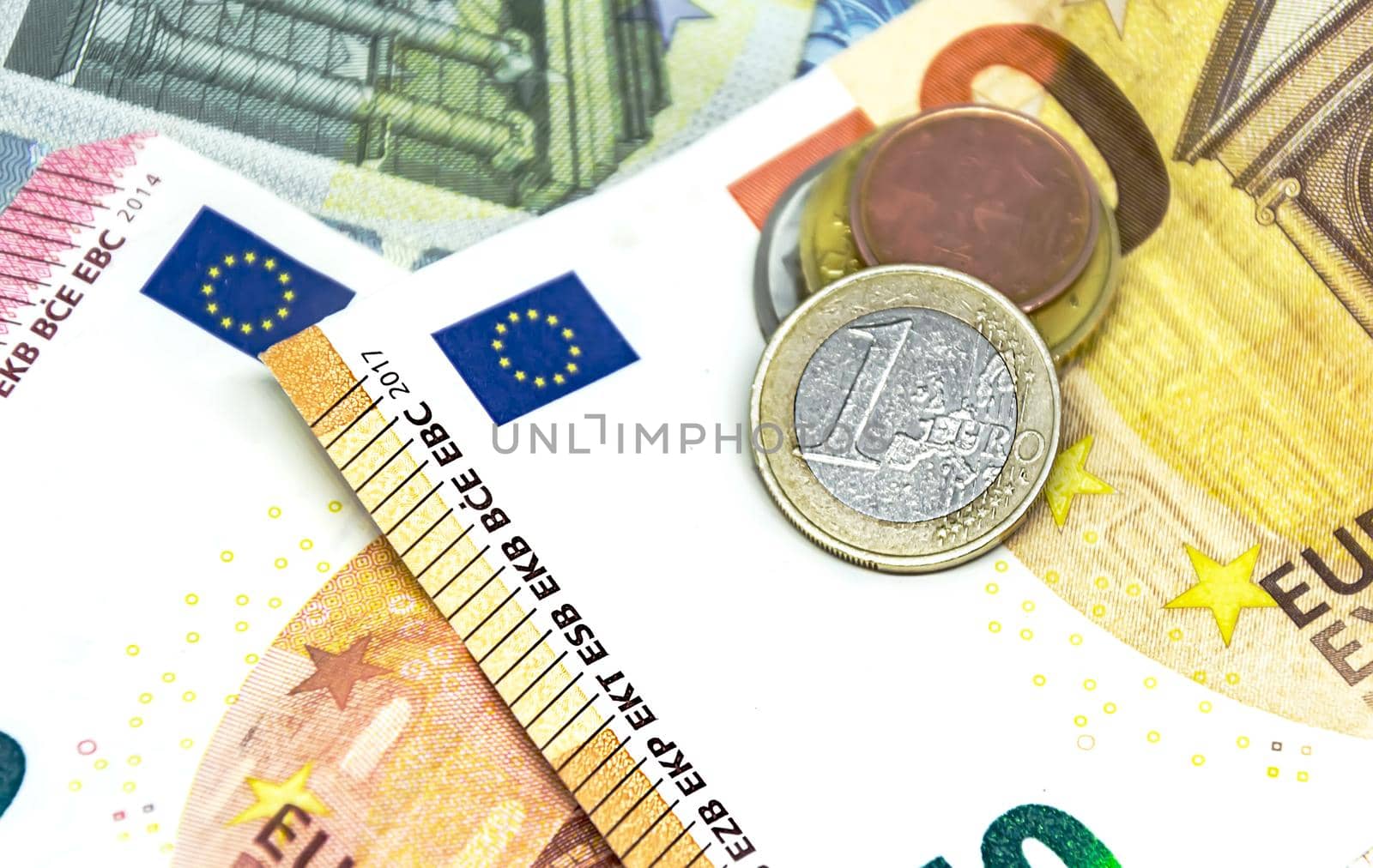 One euro coin over some banknotes of different values. The euro is the European currency. Finance, economy and business. Cash and savings