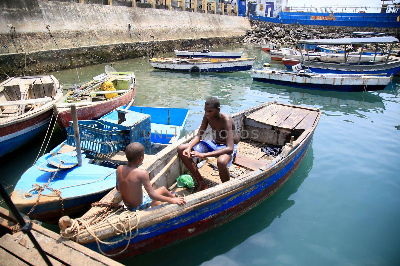 salvador, bahia, brazil - february 17, 2021: children playing next to boats in the port of Sao Joaquim fair in the city of Salvador.