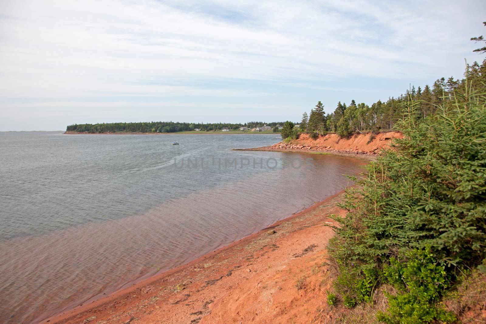 Red clay beach with sand on the ocean on a summer day in Prince Edward island